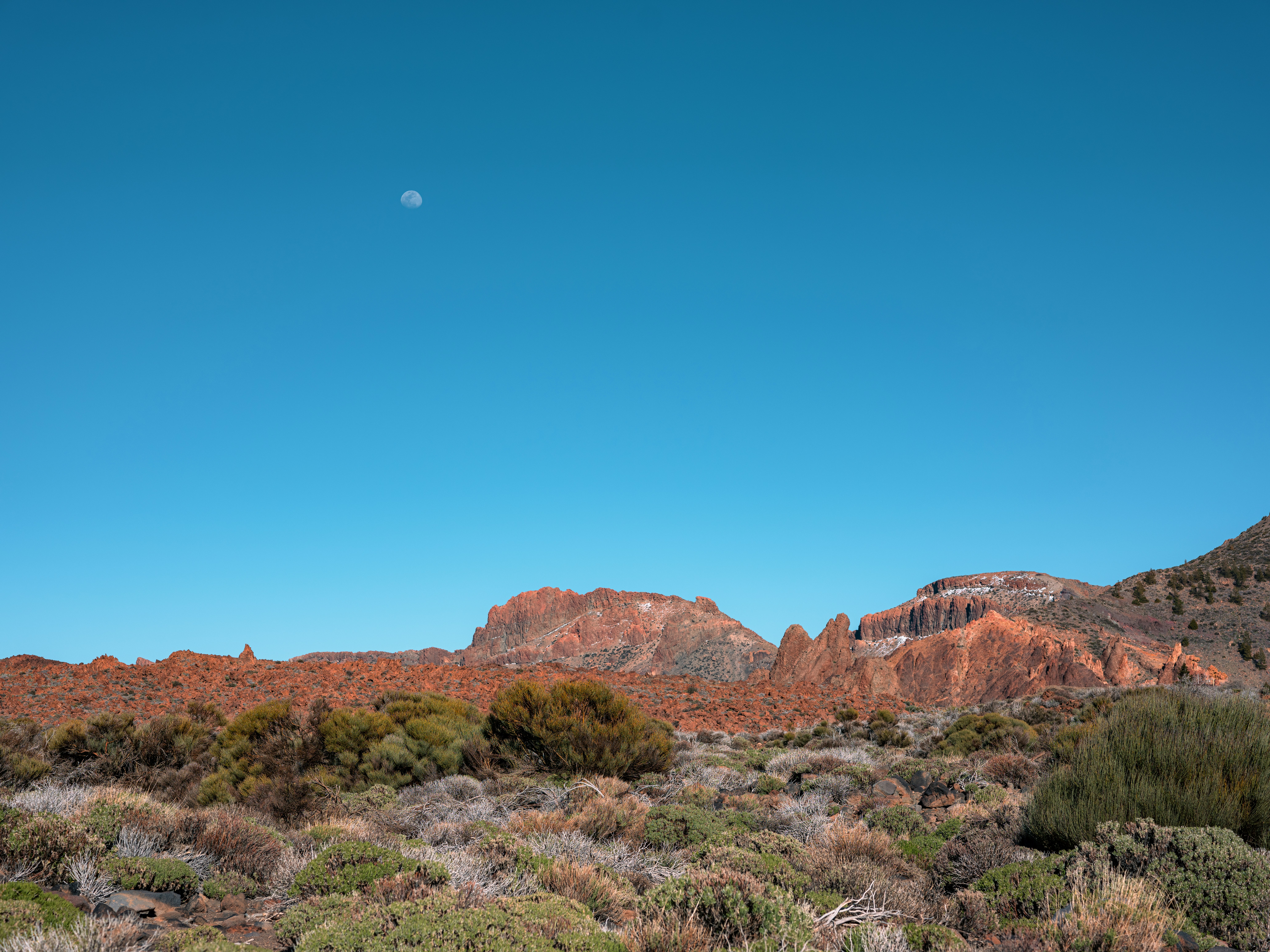 Paisagem árida com colinas rochosas e céu azul claro