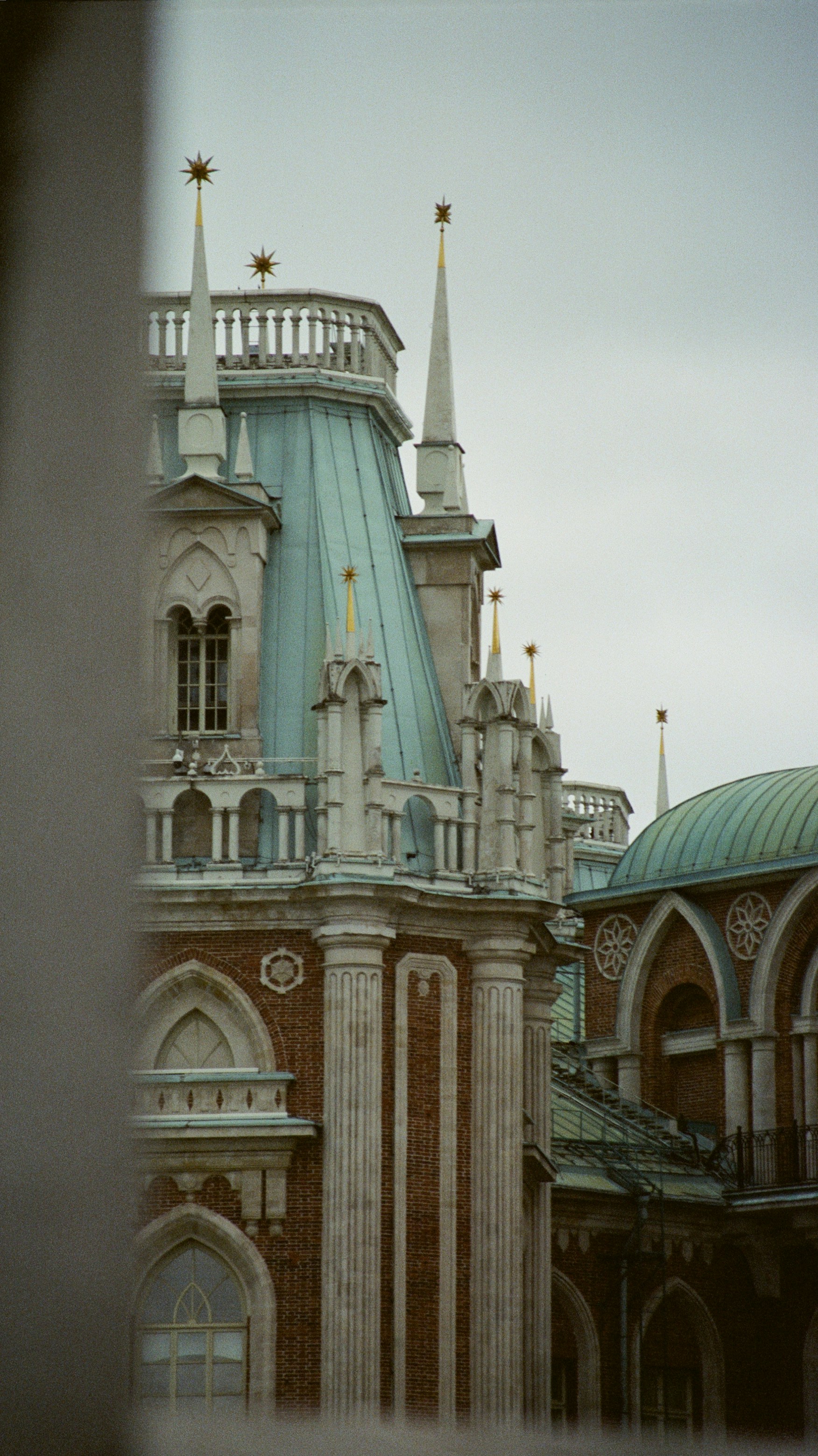 Ornate brick building with copper roofs and spires