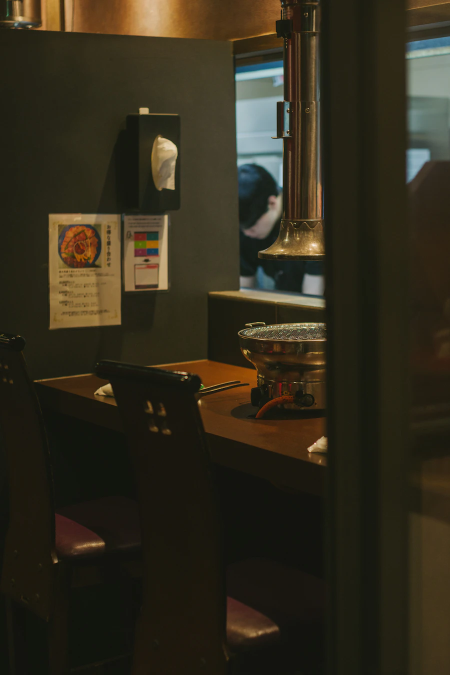 A dark restaurant interior with grill tables