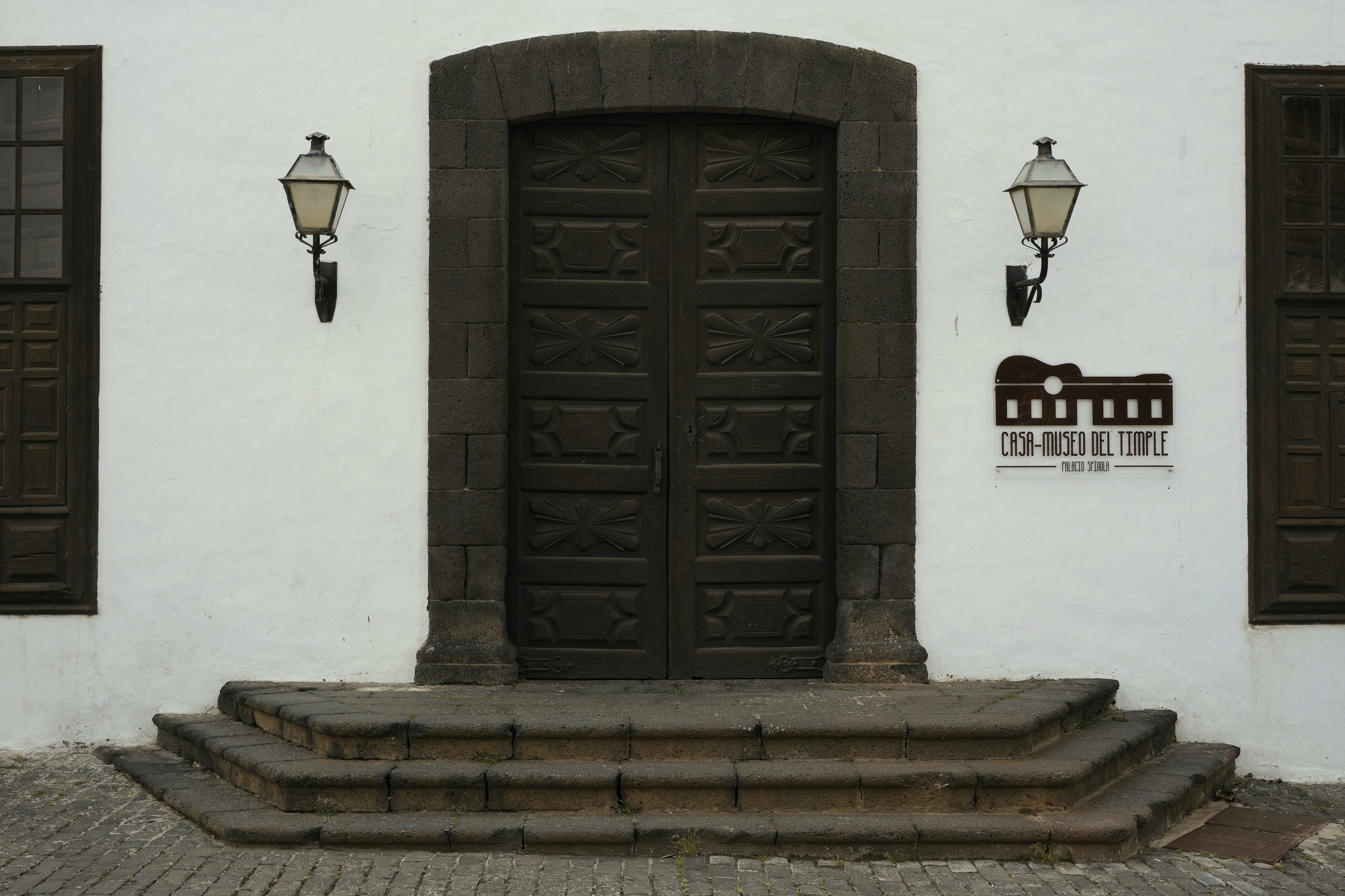 Large wooden doors with stone archway and lanterns