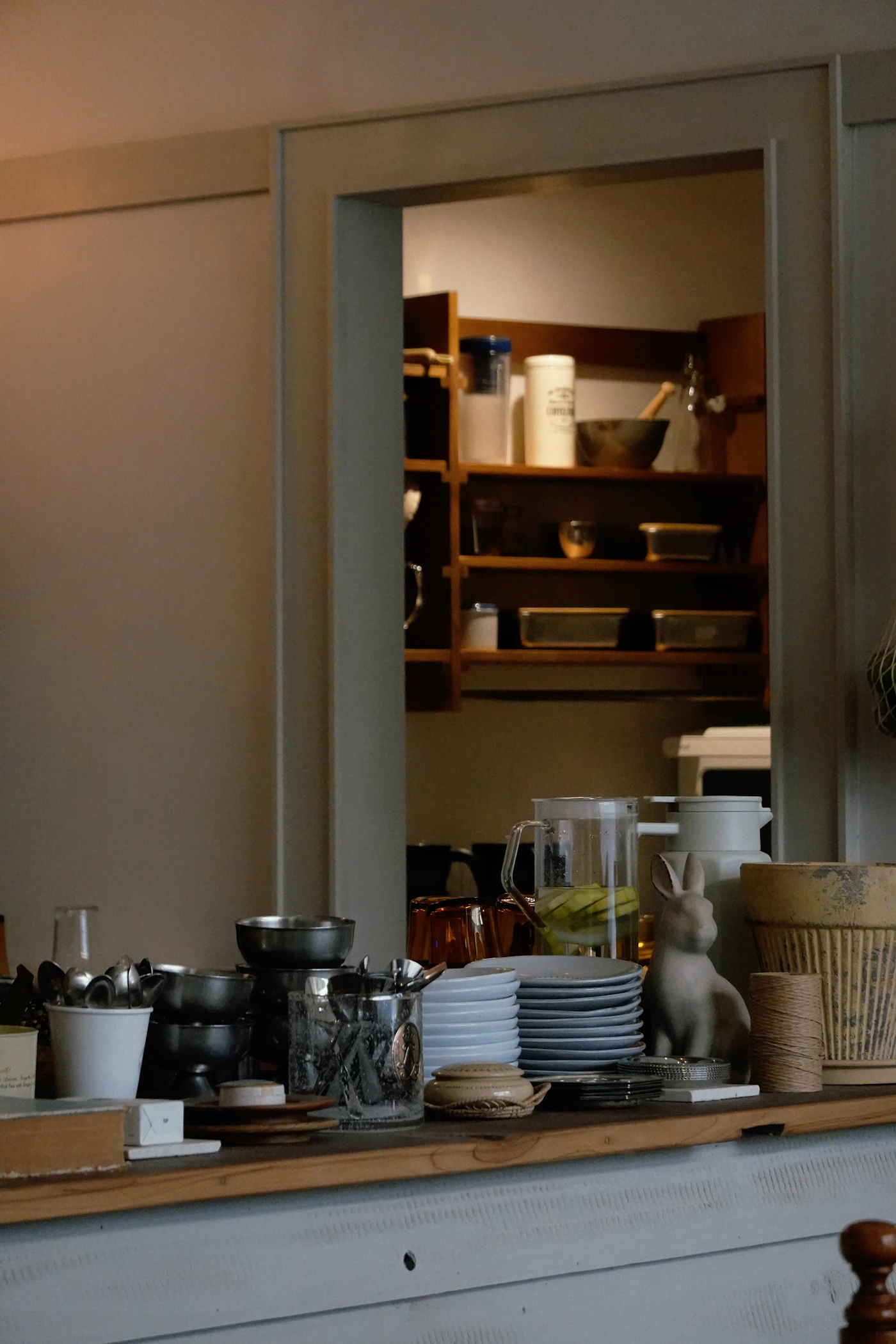 Organized kitchen shelving with jars dishes and everyday kitchenware