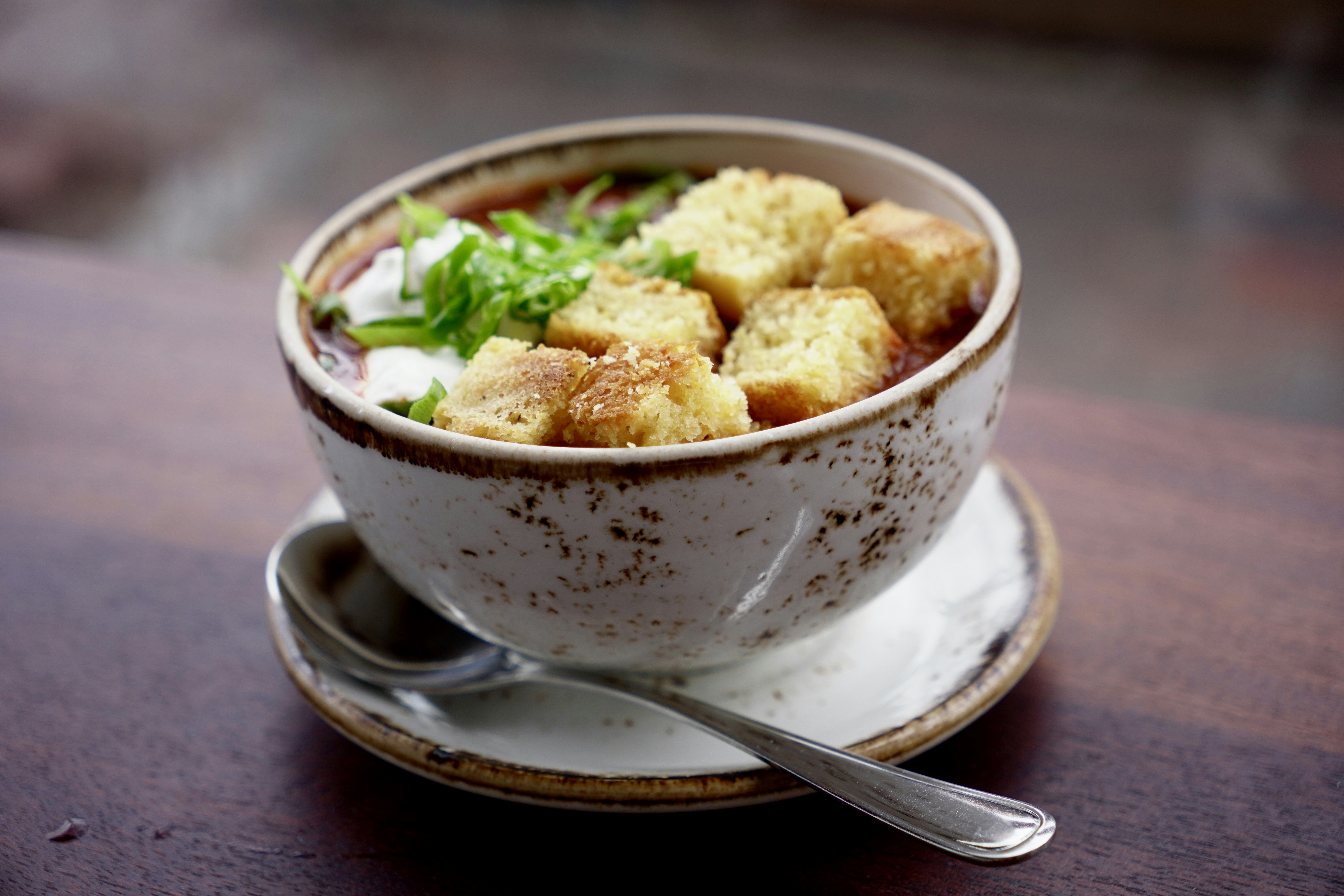Cuenco de sopa cubierto con picatostes y hierbas