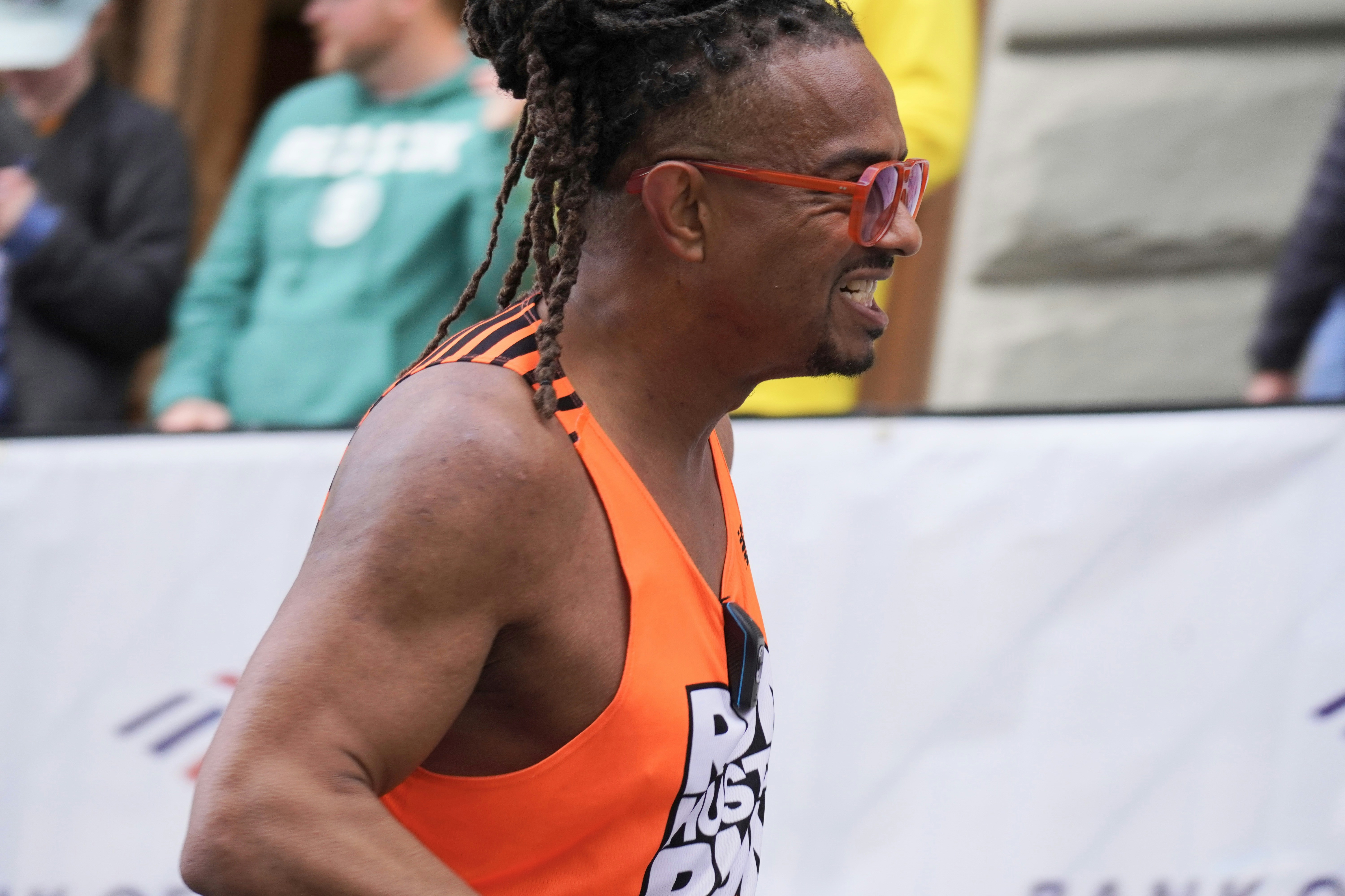 Man with dreadlocks and sunglasses running race