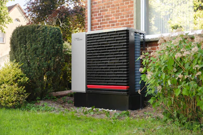 Outdoor heat pump unit next to a brick building