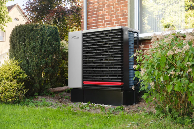 Outdoor heat pump unit next to a modern home