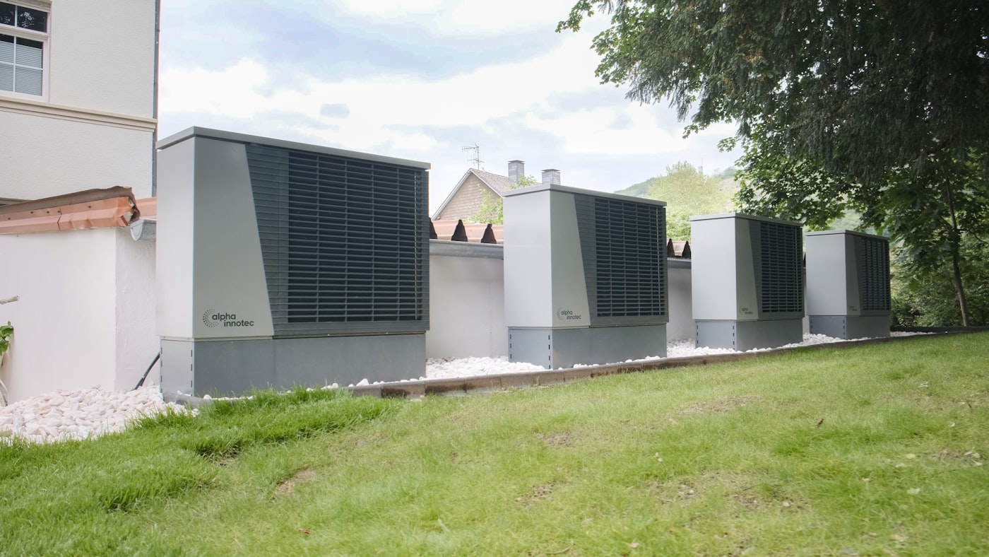 Industrial heat pump units lined up outside a modern building