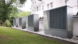 Four industrial air conditioning units lined up outside building