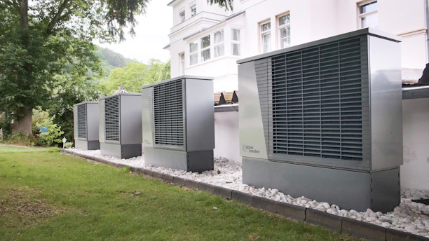 Four industrial air conditioning units lined up outside building