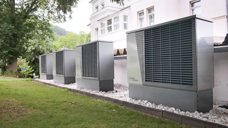 Four industrial air conditioning units lined up outside building
