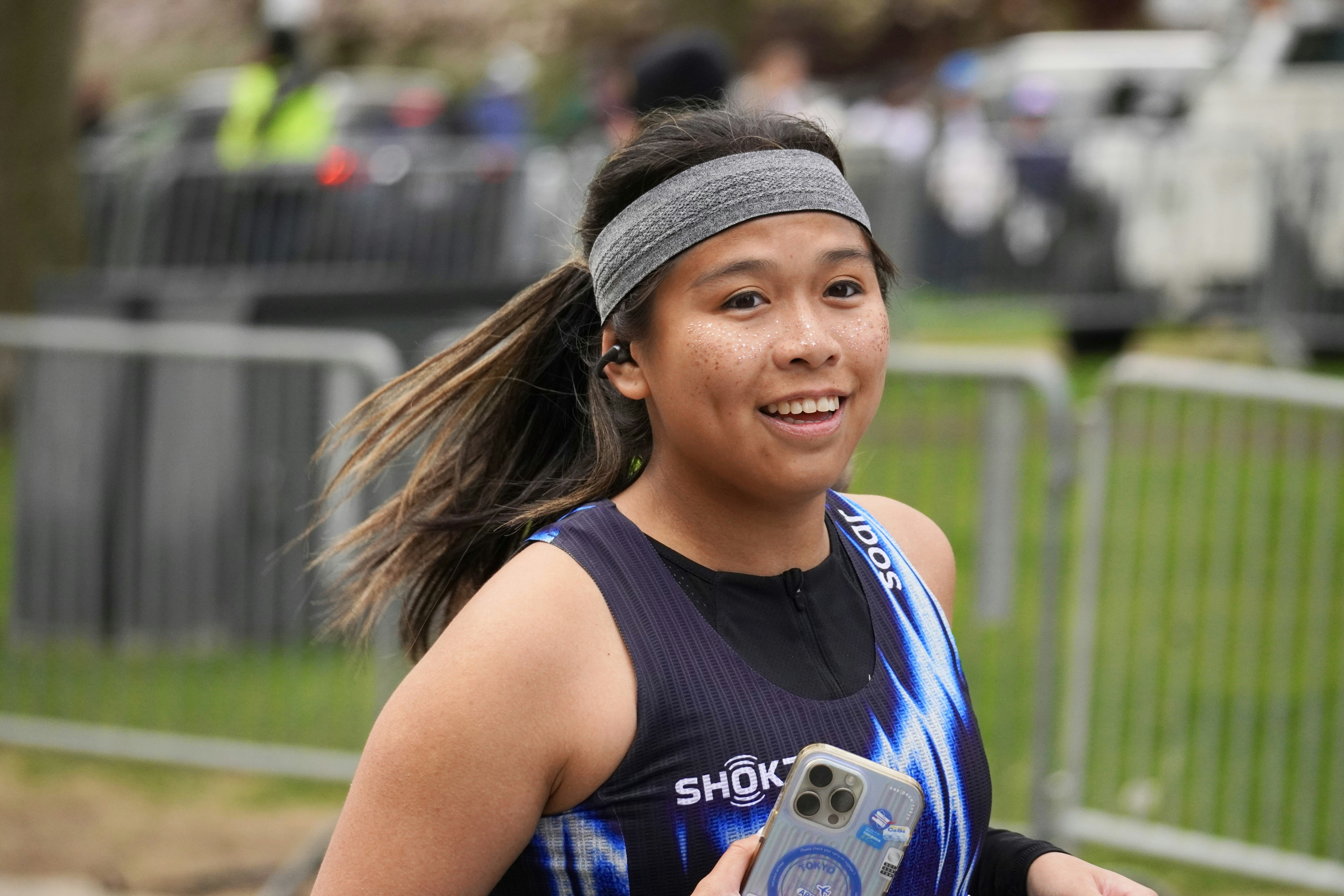 Young woman running with phone in hand