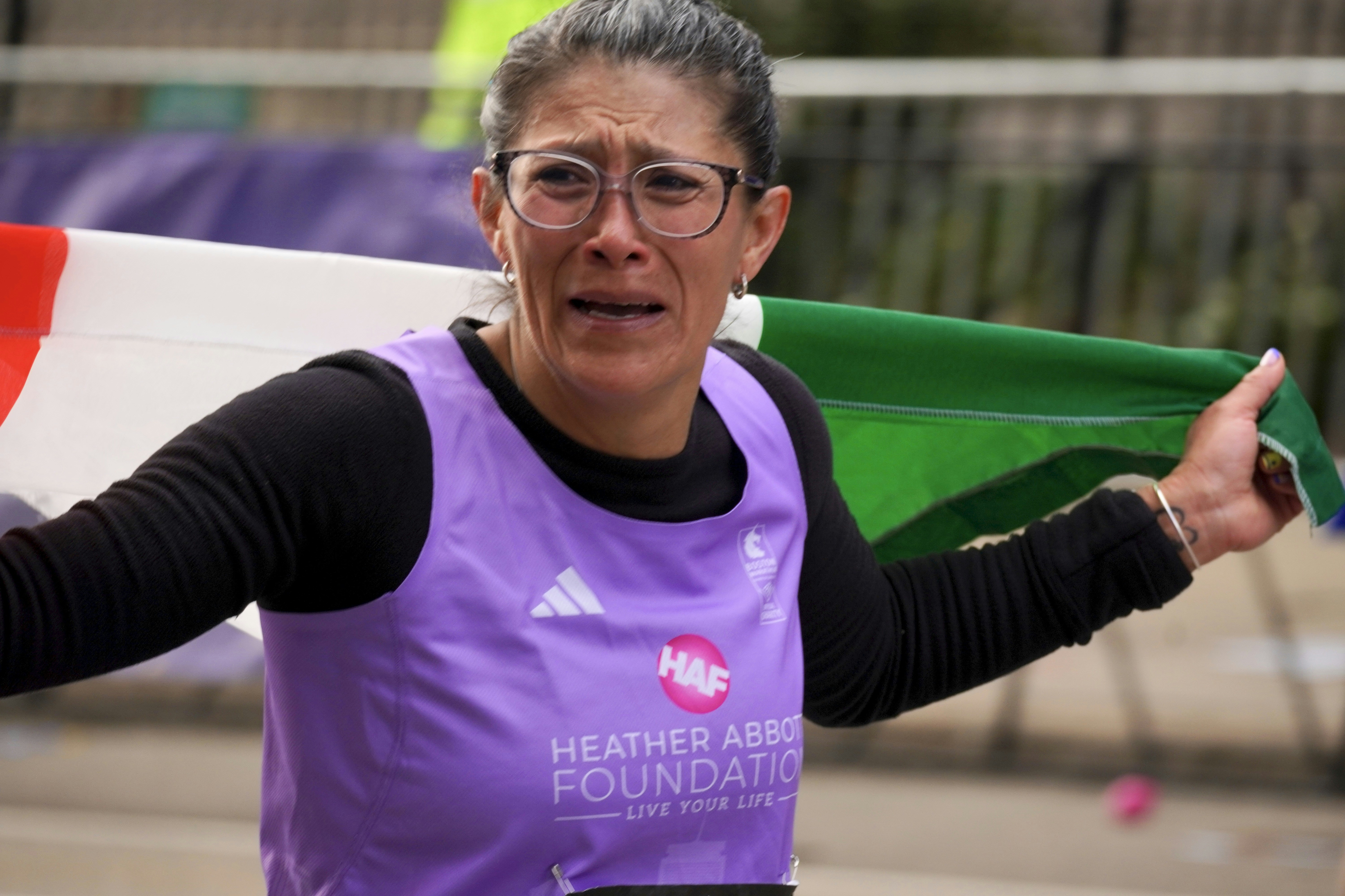 Woman cries holding a mexican flag during a race