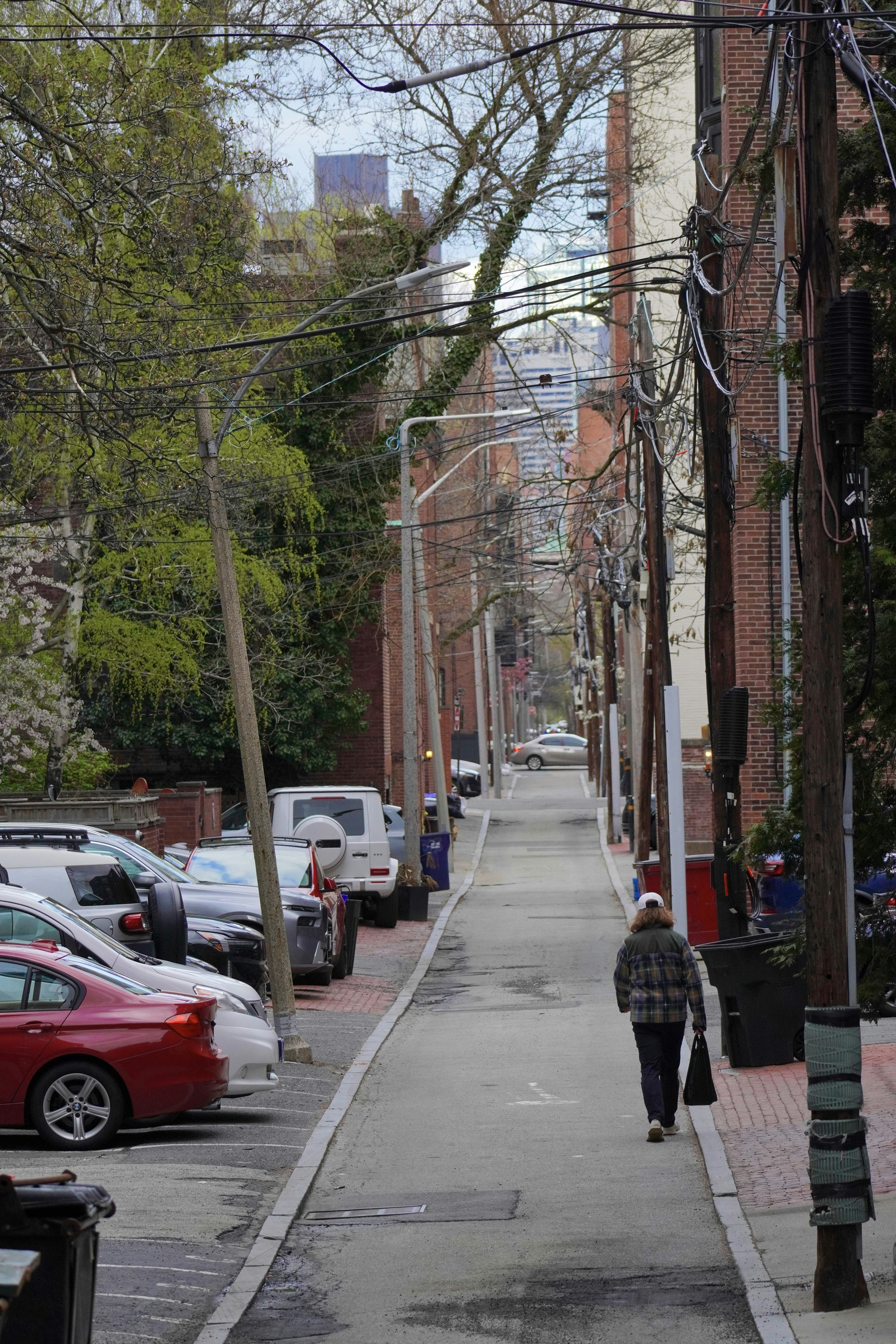 A person walks down a narrow alleyway between buildings.