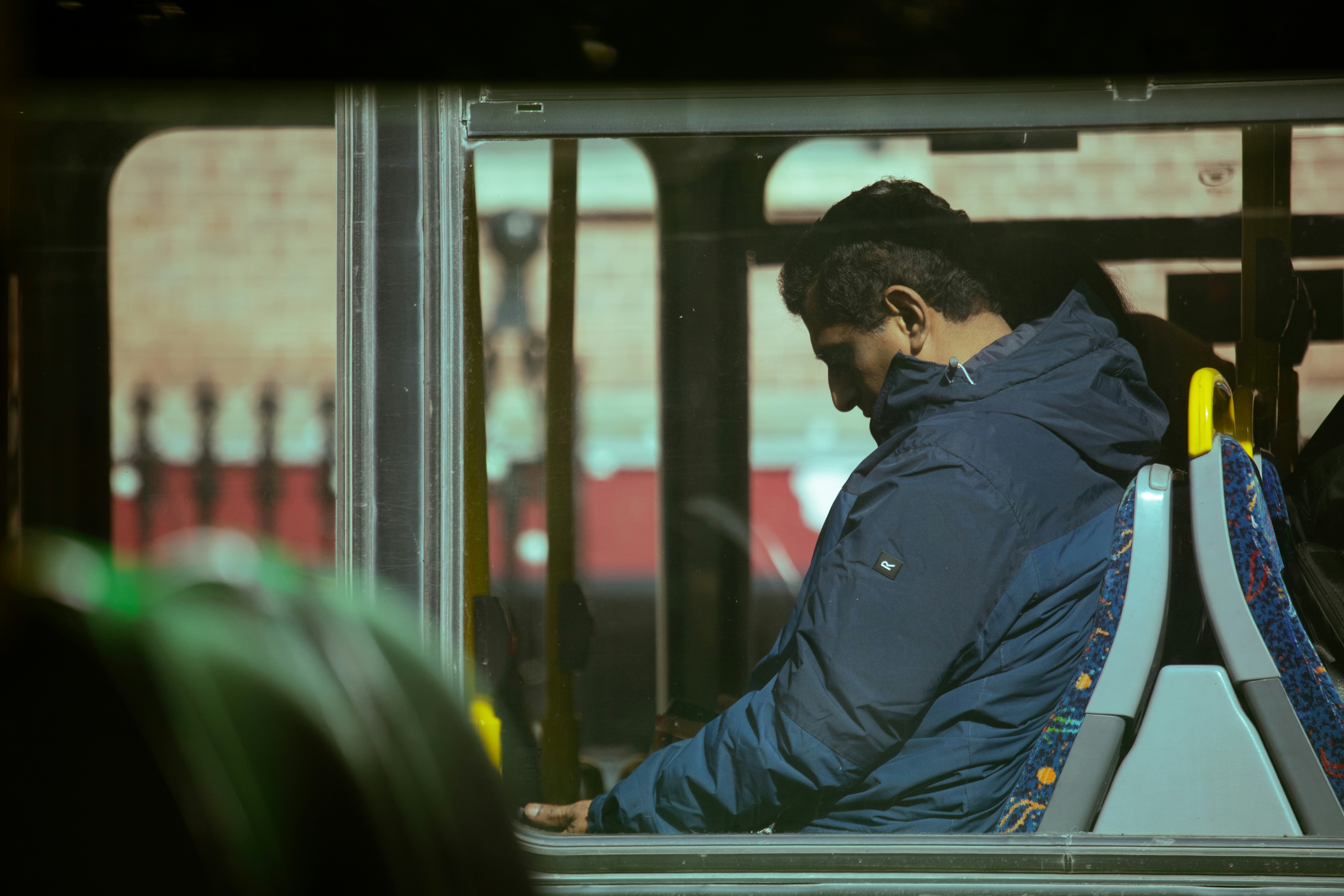 Man dozing by the window on a bus