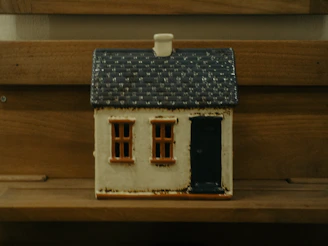A small decorative house with a dark blue roof