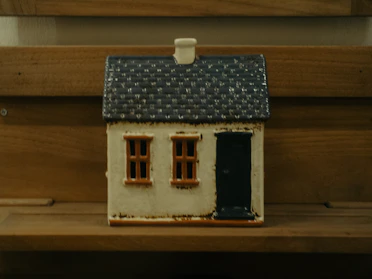 A small decorative house with a dark blue roof
