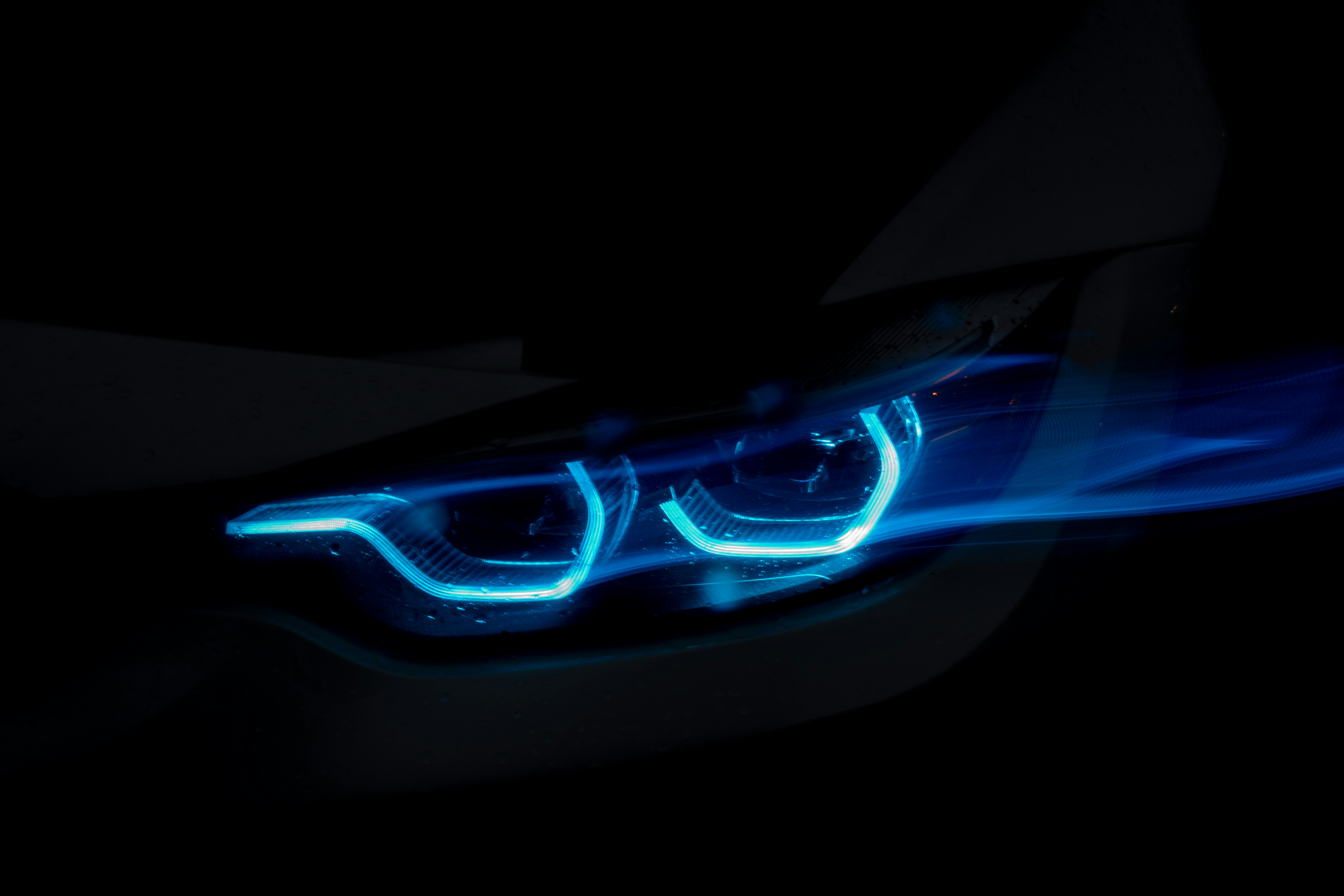 Close-up of a car's glowing blue headlights at night