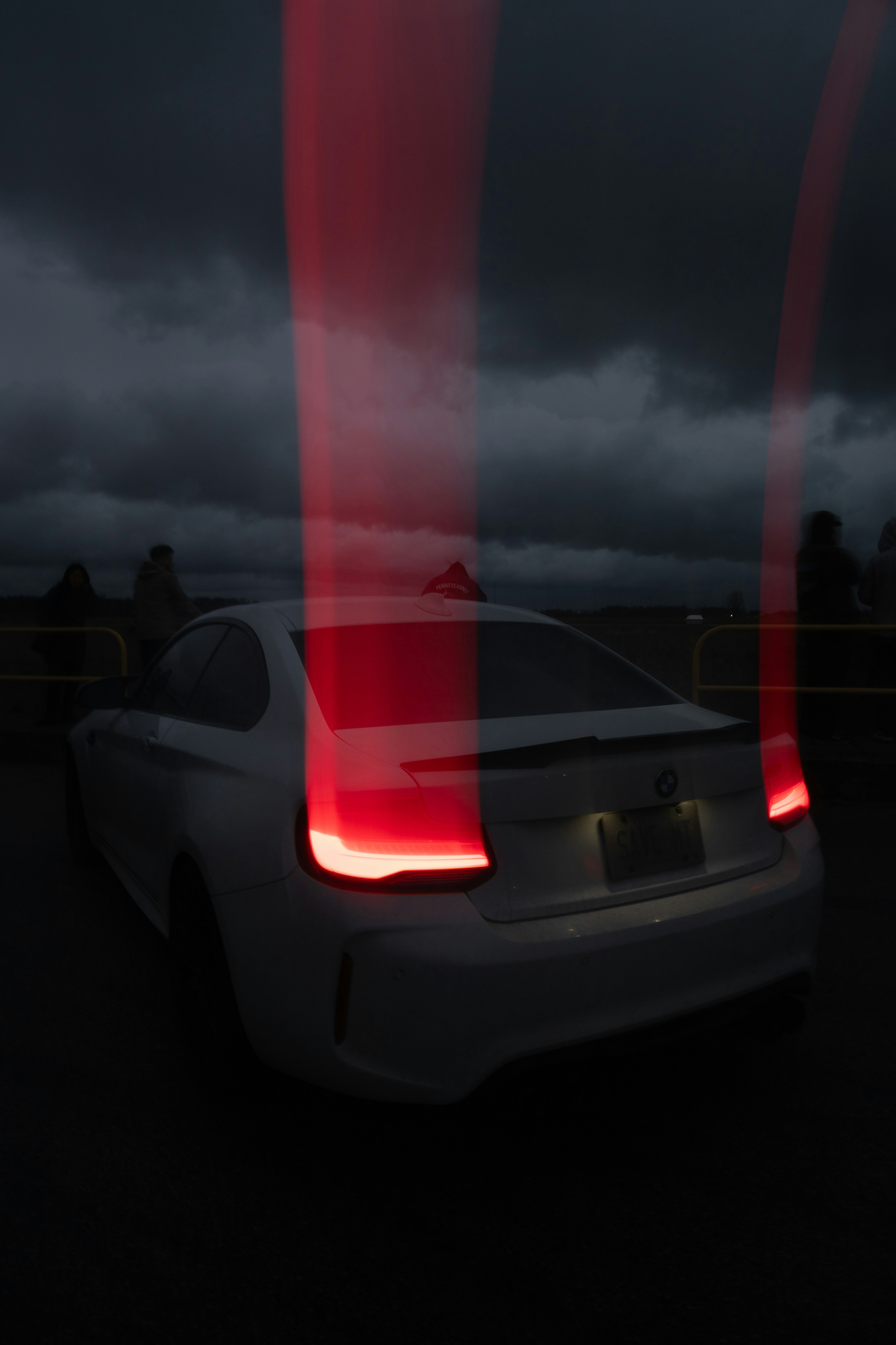 White car with red light streaks at night