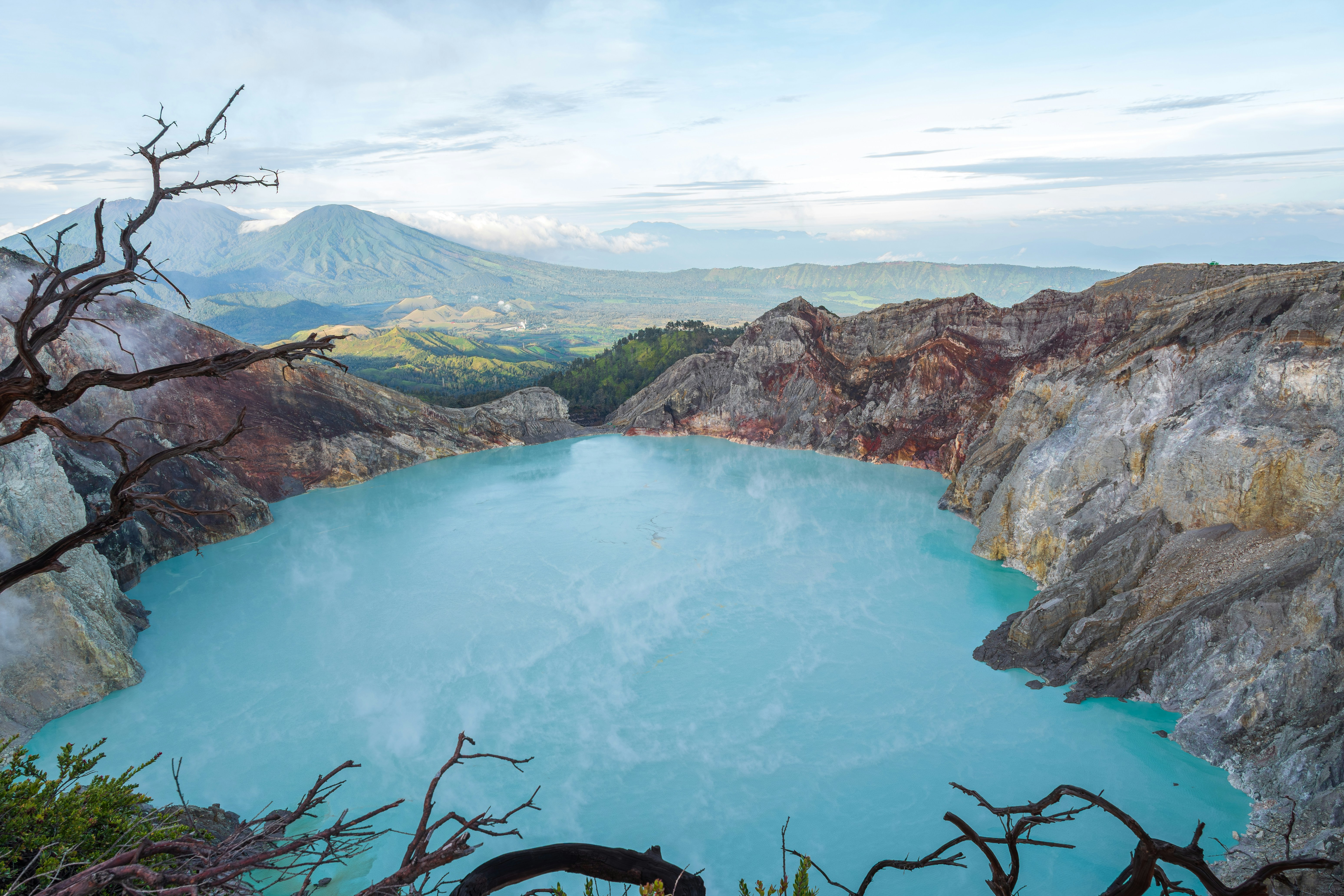 Turquoise lake in a volcanic crater with mountains.