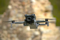 A gray drone flies in the air.