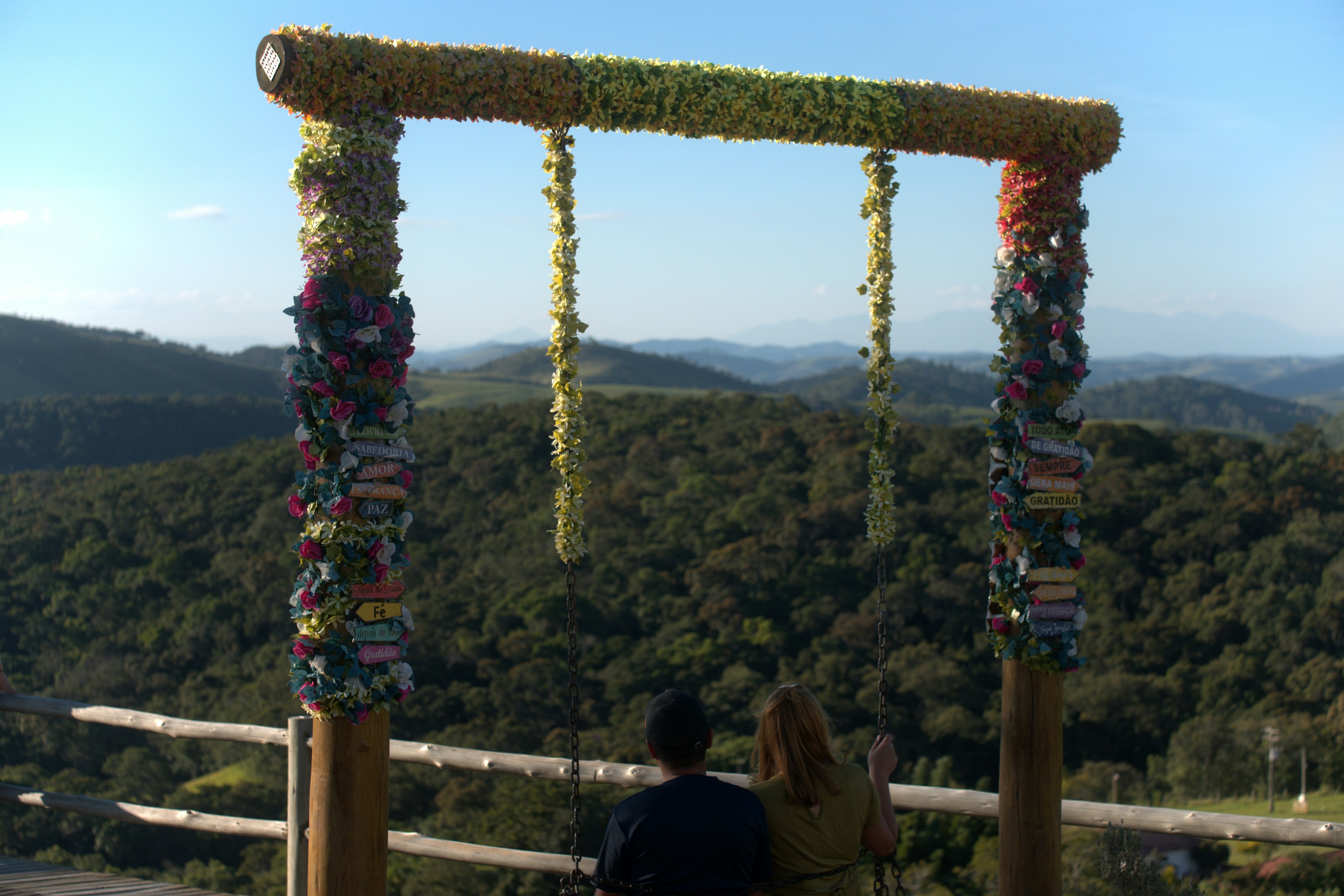 Couple looking at a swing set with a forest view.