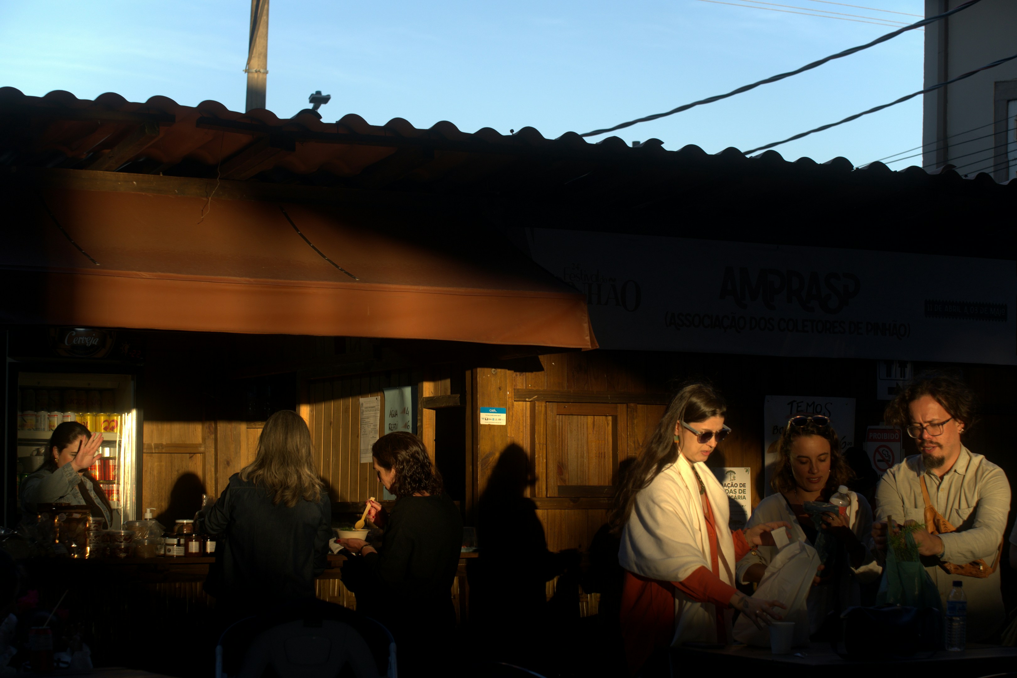 People gathered outside a cafe at sunset.