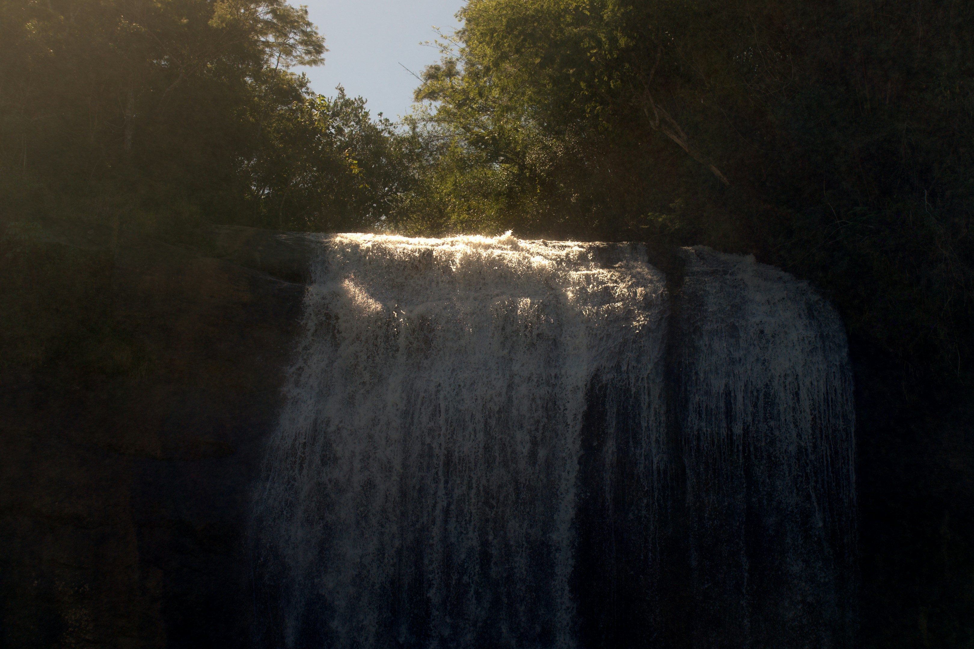A wide waterfall cascades down a rocky cliff face.