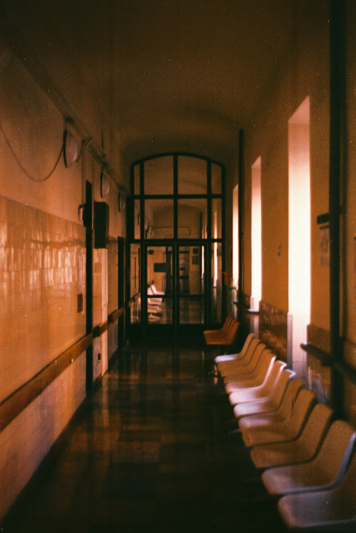 Pasillo vacío de un hospital por la noche, en tonos cálidos y oscuros