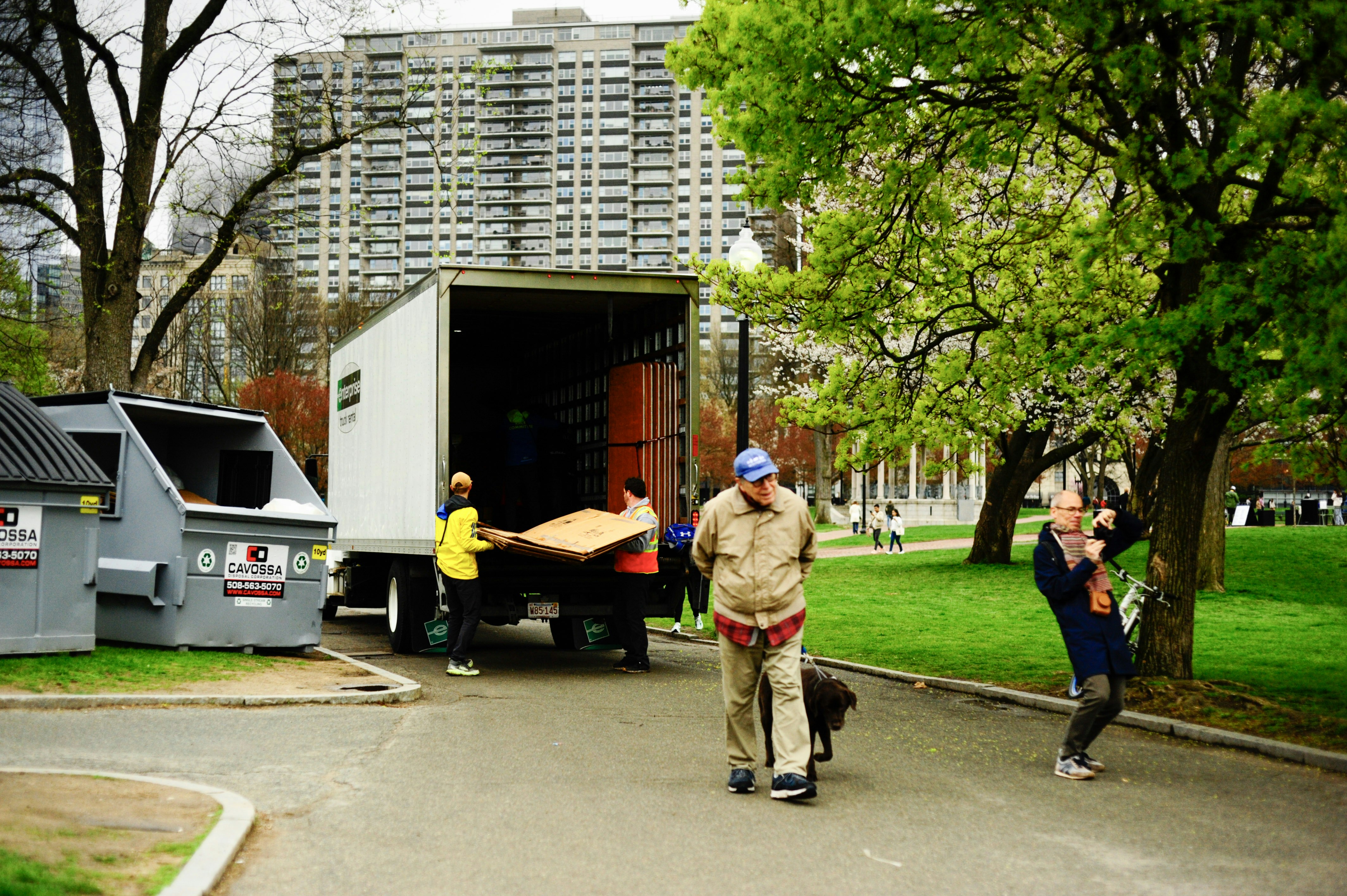People unloading furniture from a moving truck outdoors.