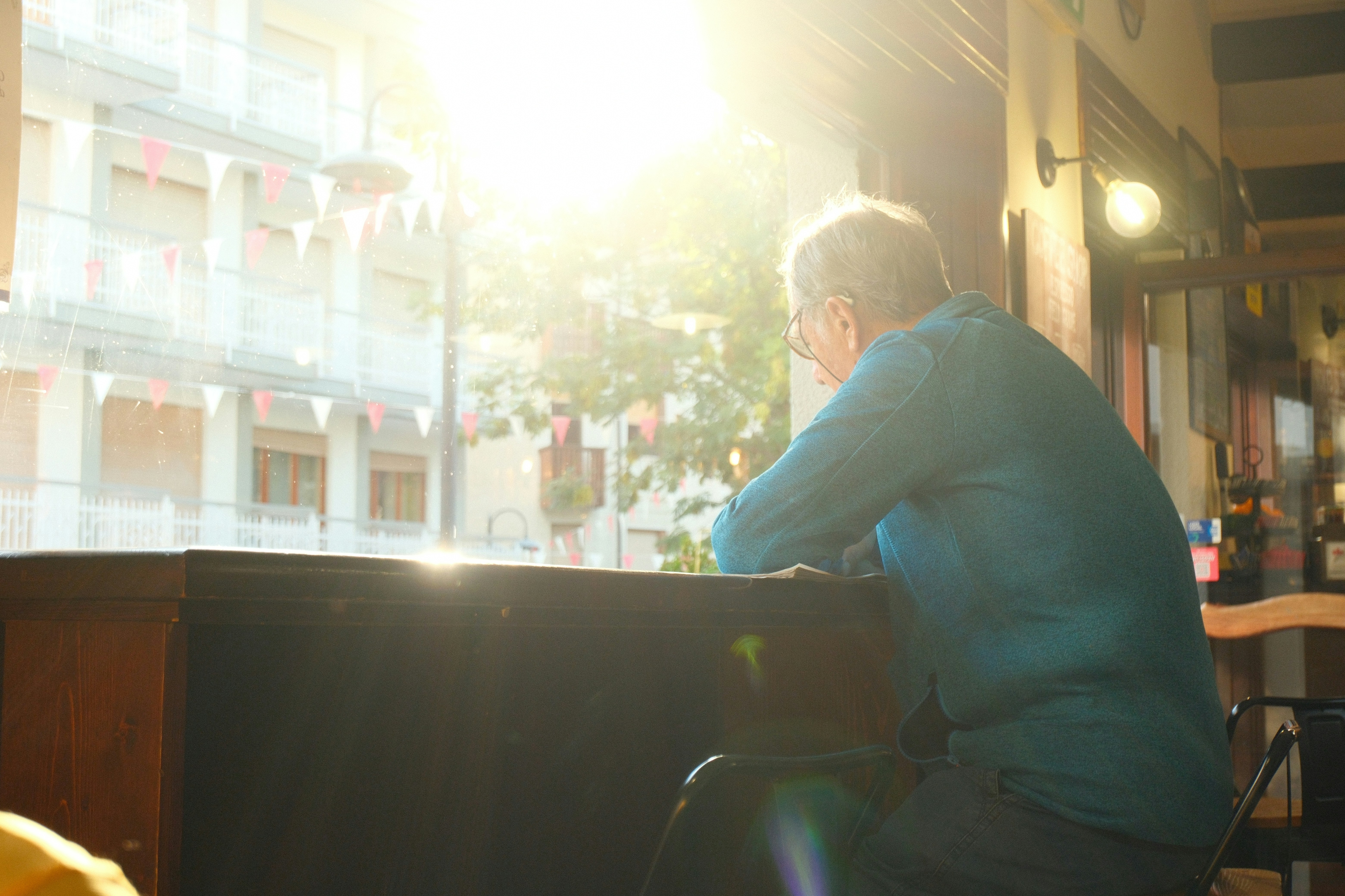 Man looking out a sunlit window indoors