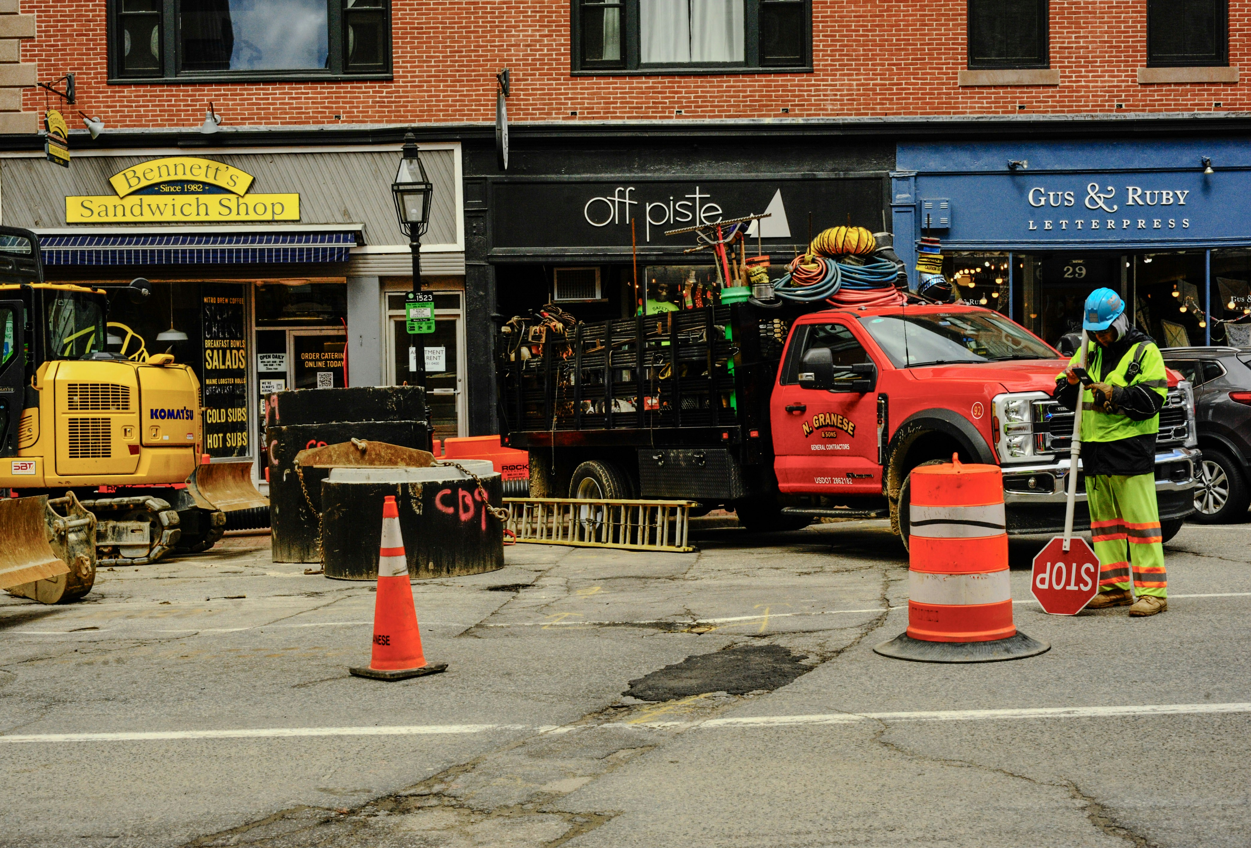Construction workers and equipment on a city street.