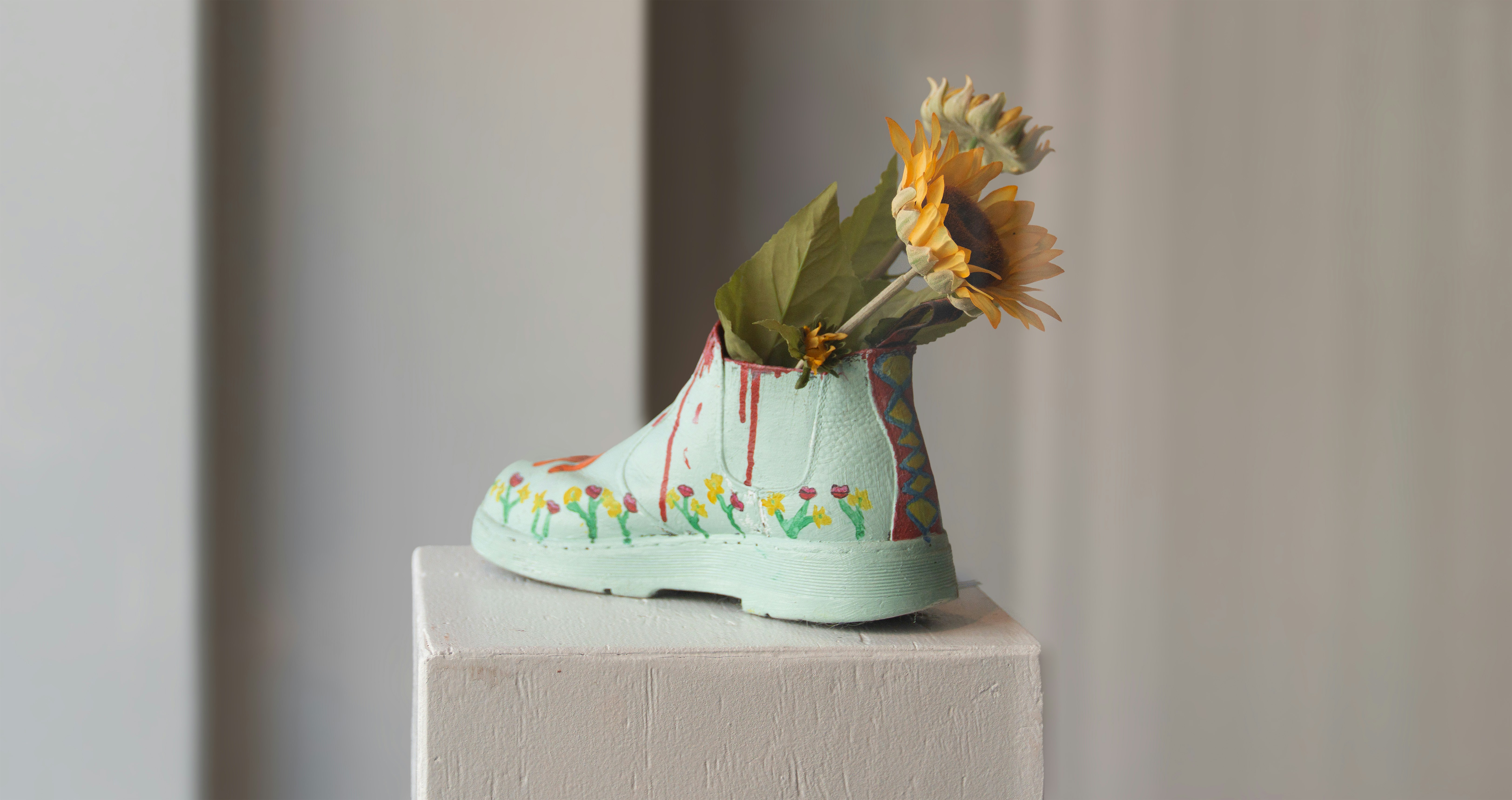 A painted shoe with flowers as a vase