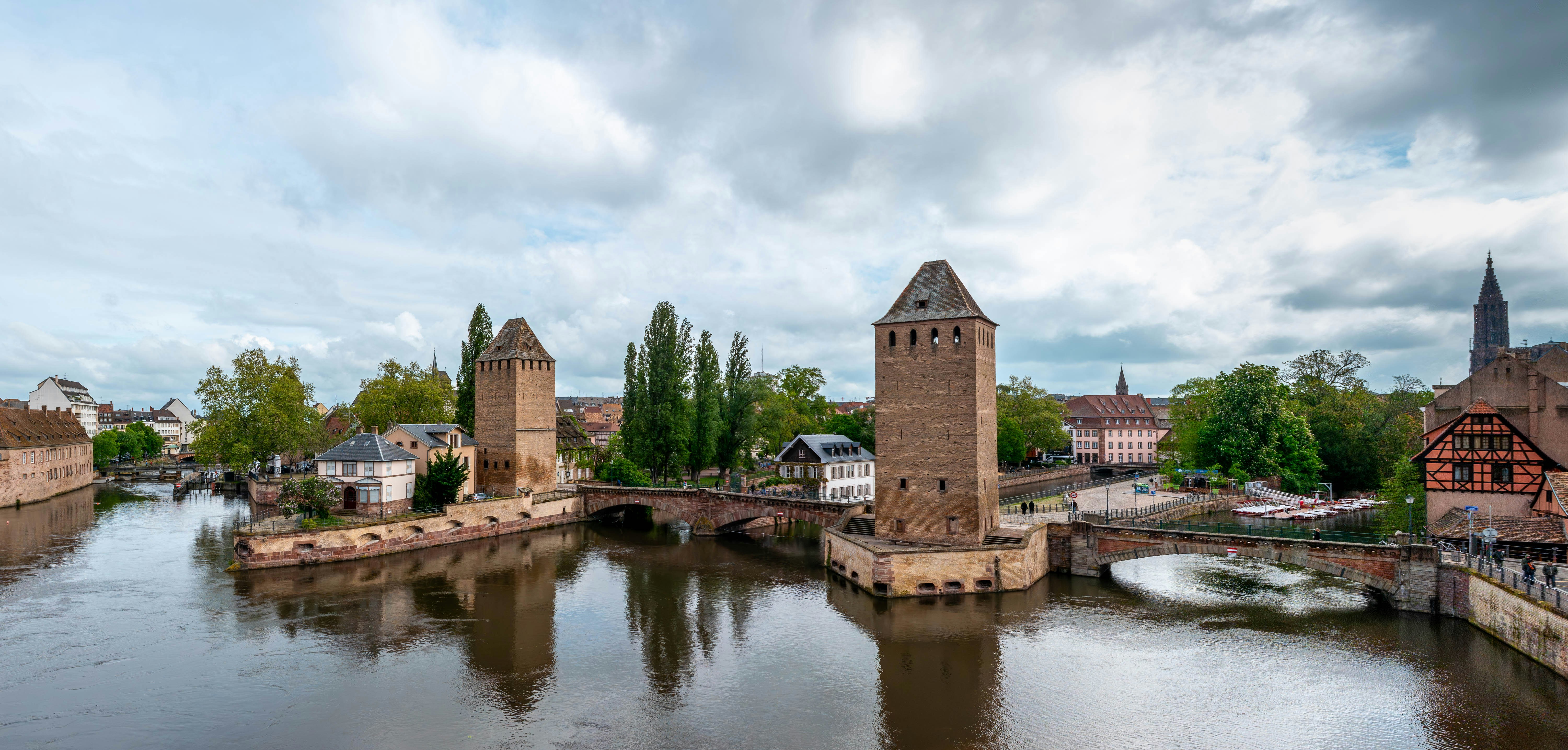 Towers and bridge over a river with cloudy sky