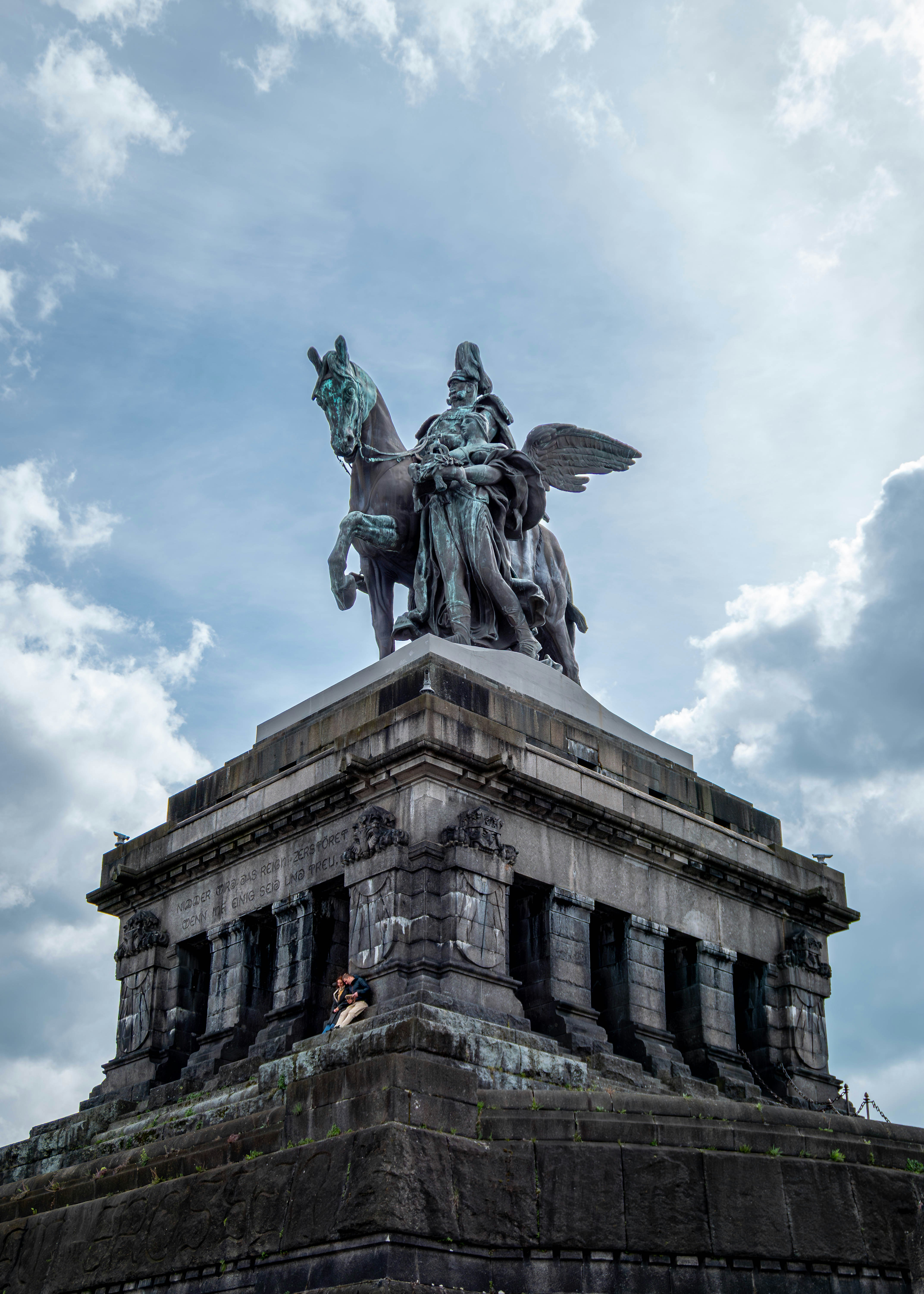 Equestrian statue atop a stone monument under cloudy sky