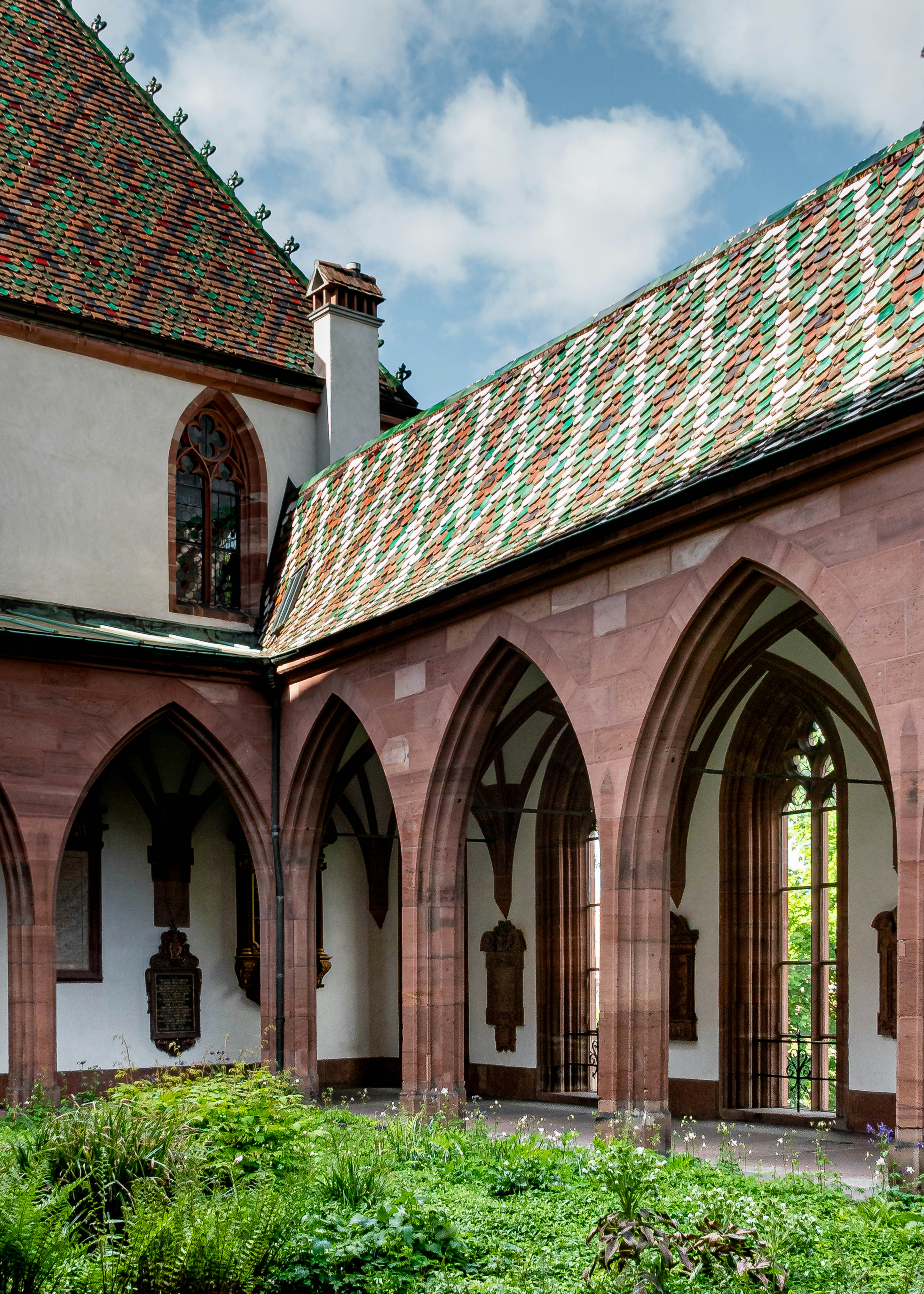 Arched cloister with green courtyard and tiled roof