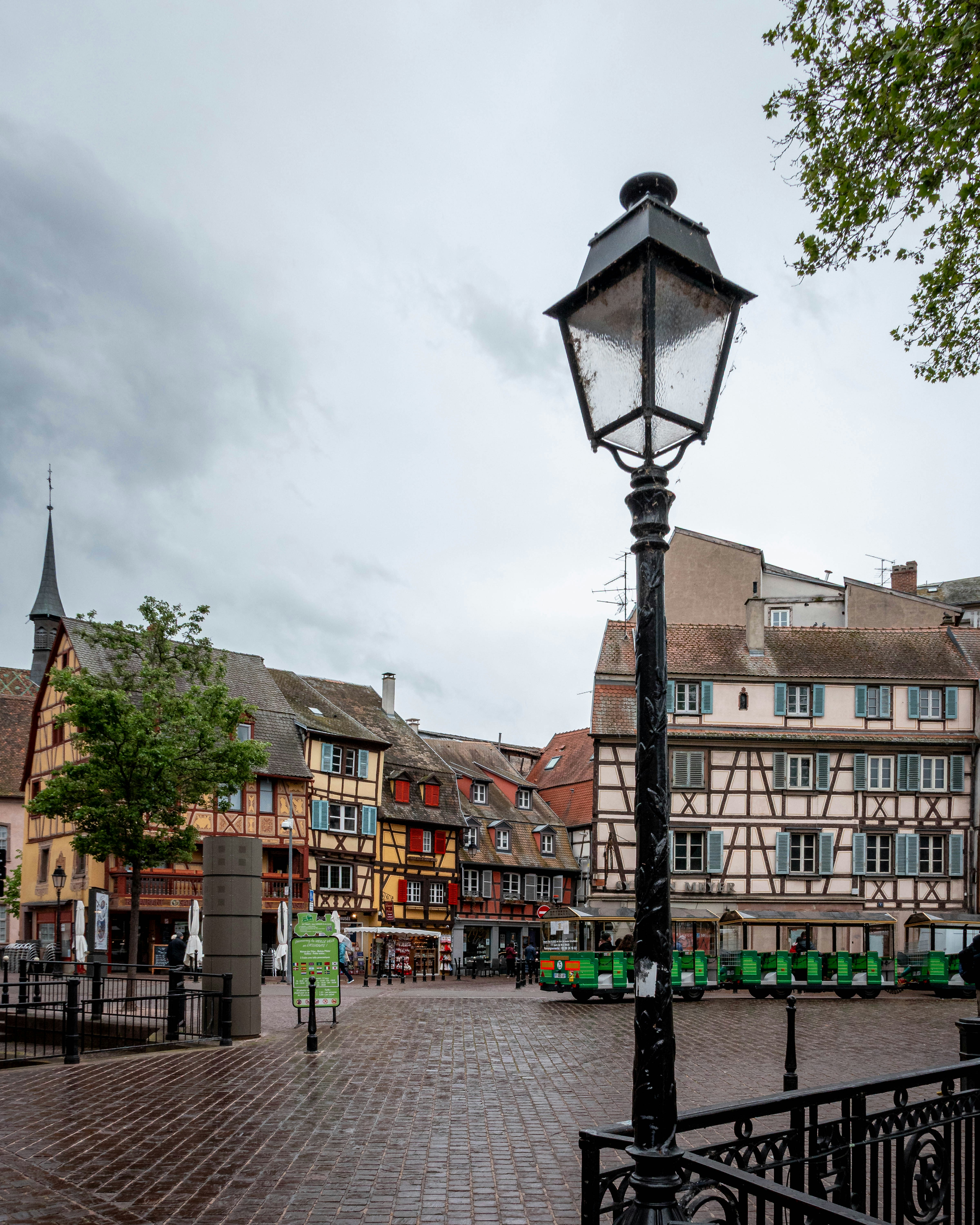 Old european town square with colorful buildings and lamppost.