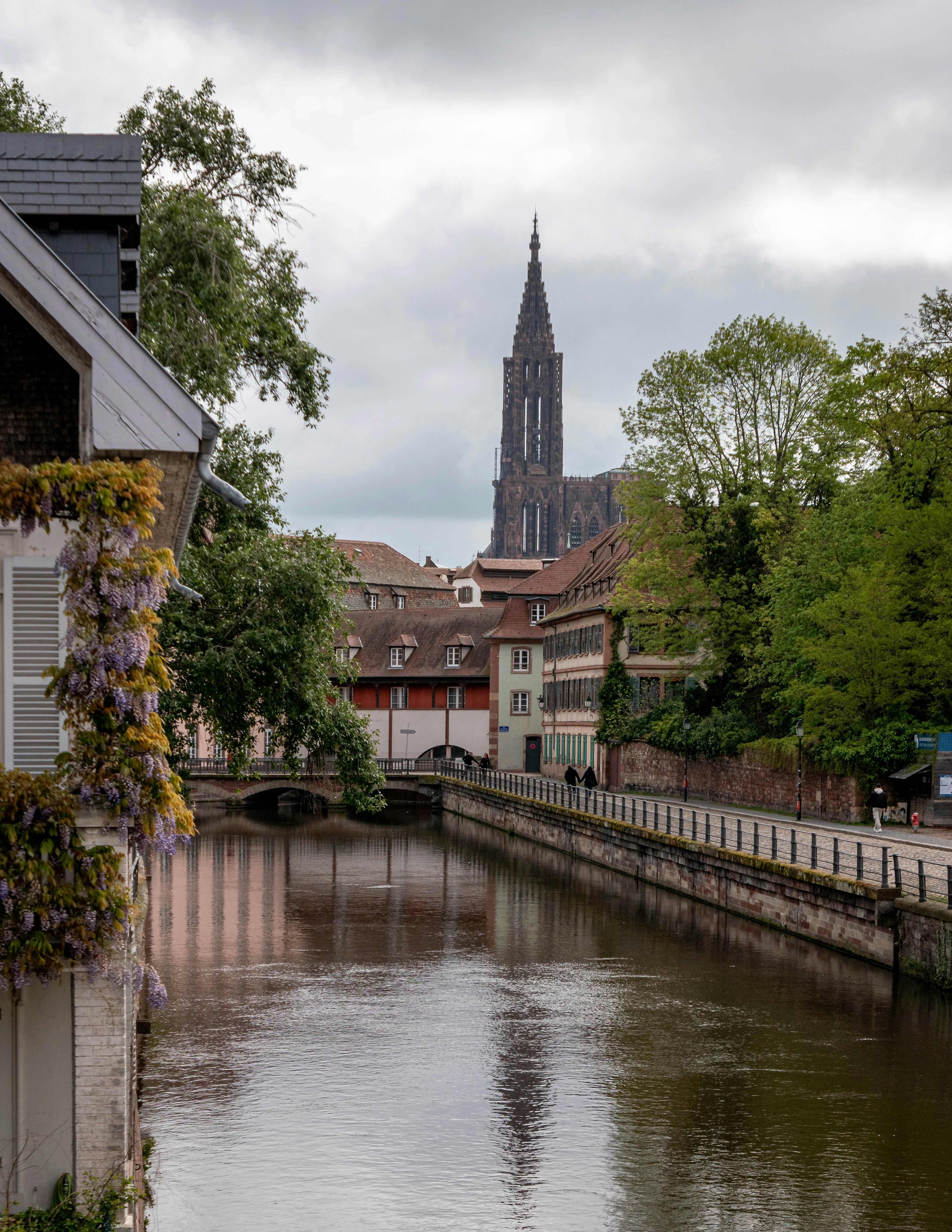 Canal with historic buildings and a tall church spire.