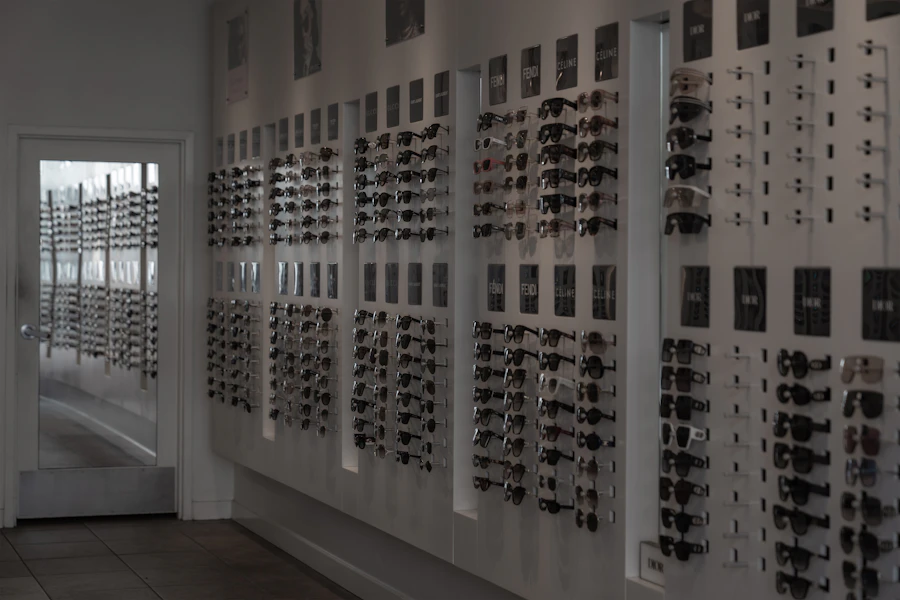 Pared de exhibición con monturas y lentes de sol en una óptica