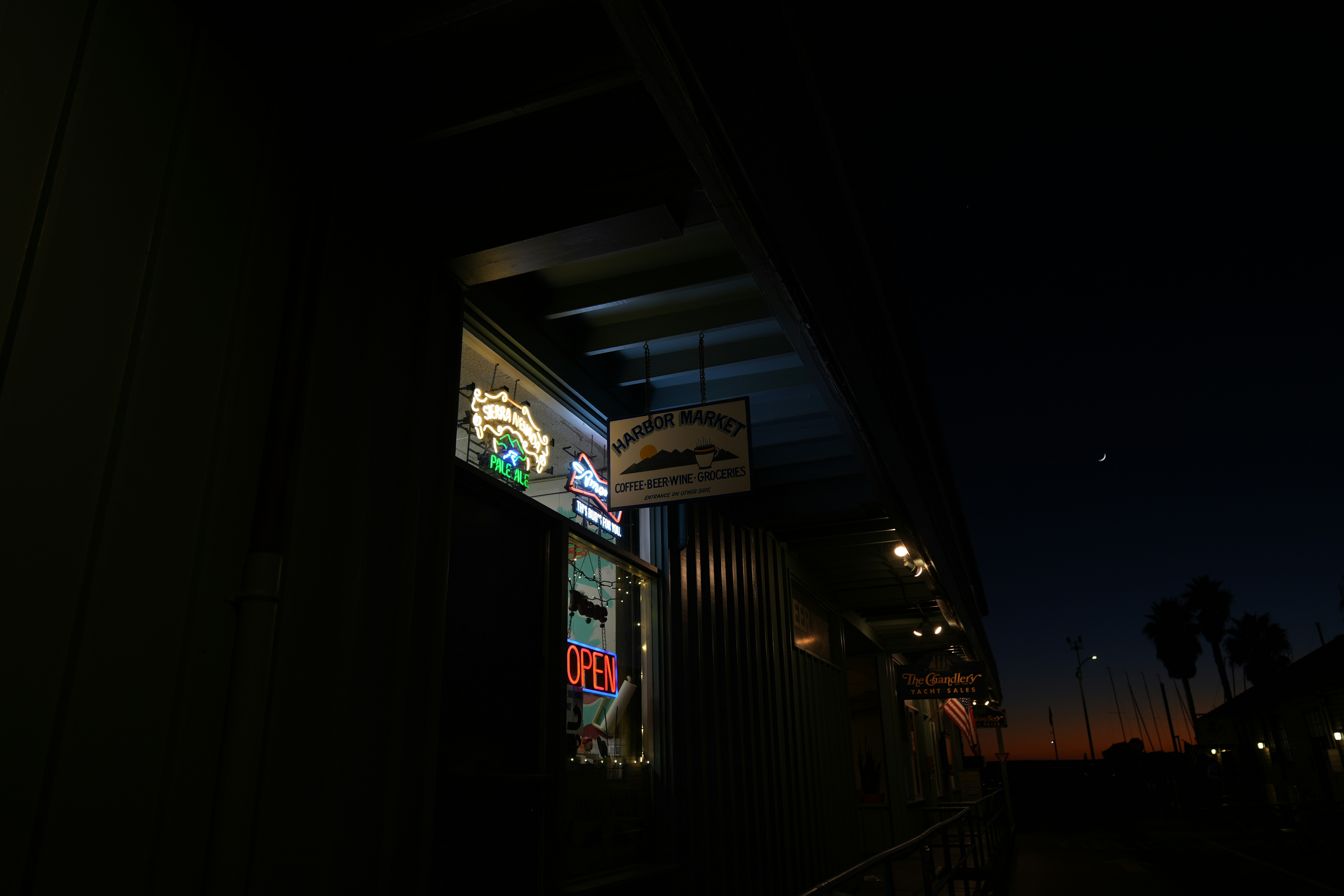 Neon signs glow brightly outside a building at dusk.