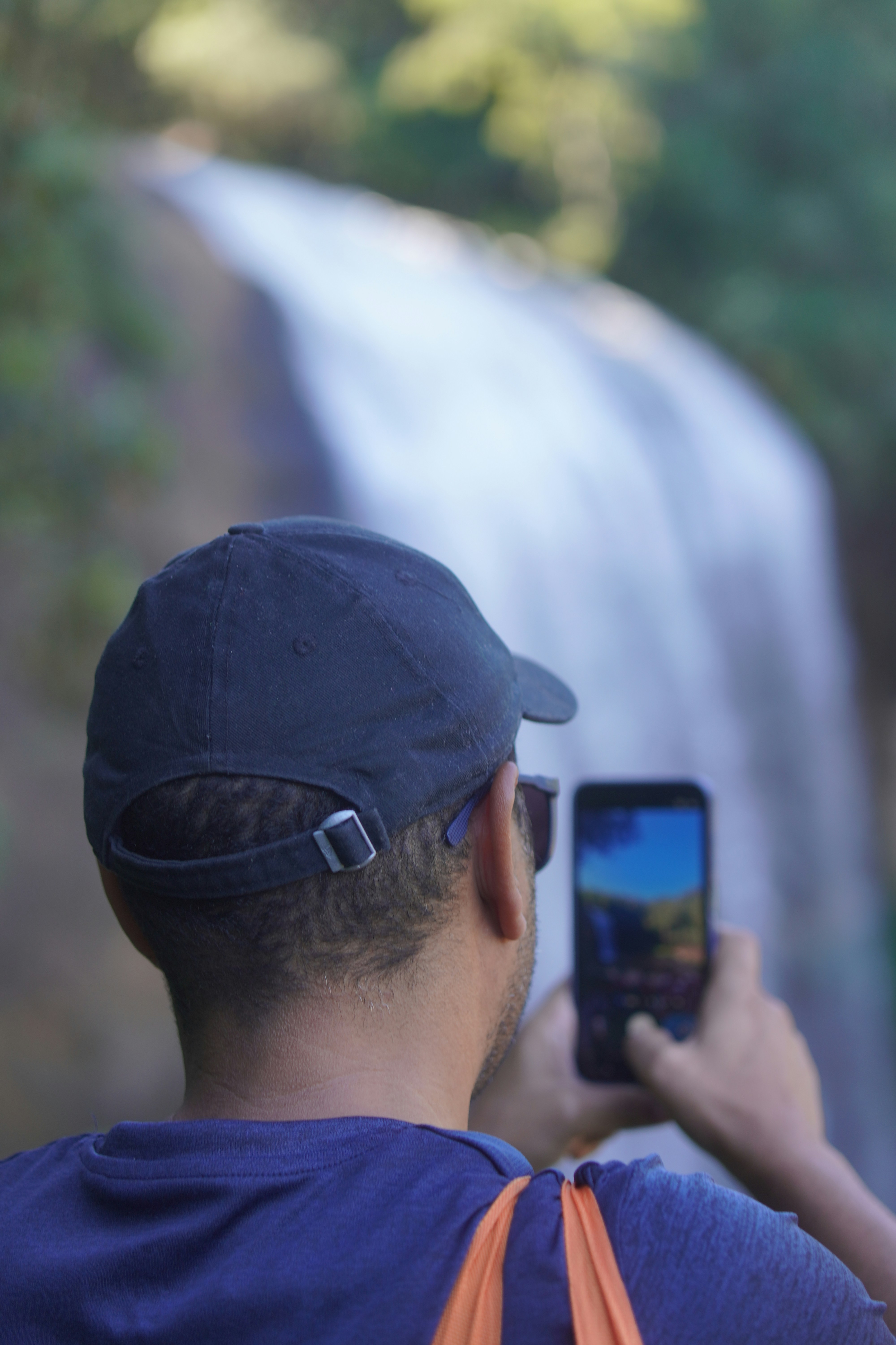 Man takes picture of waterfall with smartphone