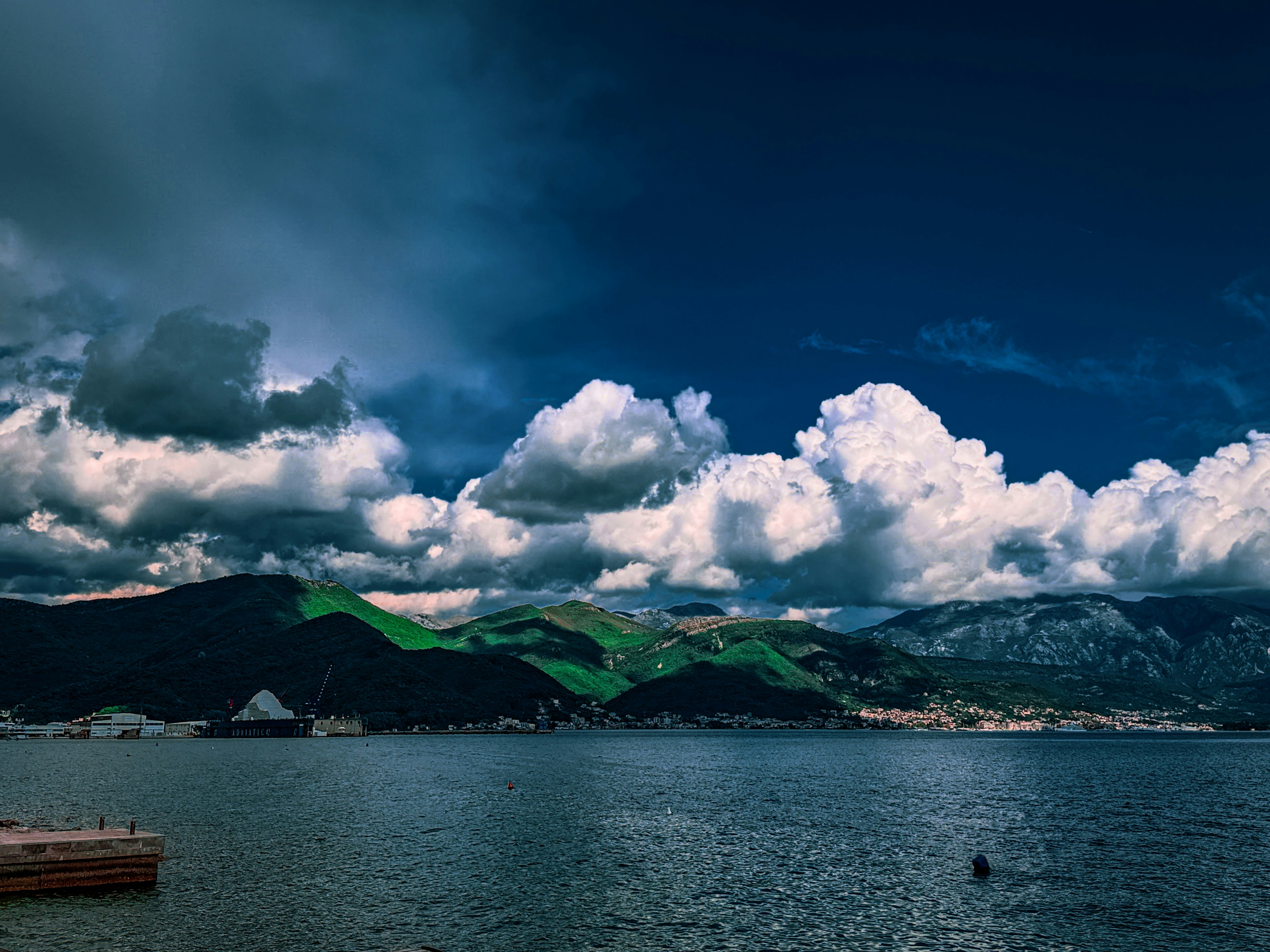 Dramatic clouds over a serene lake and mountains 풍경 사진
