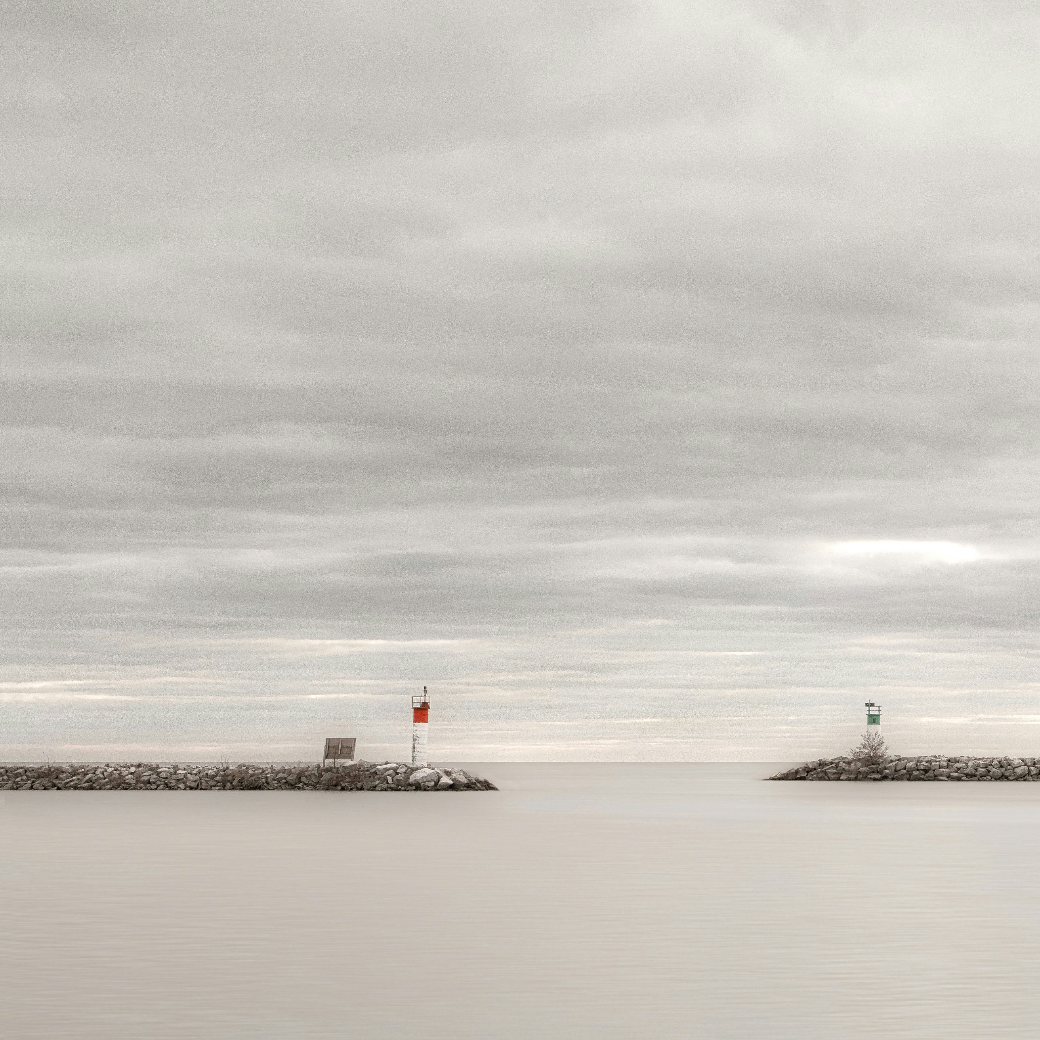 Two lighthouses mark a calm ocean entrance