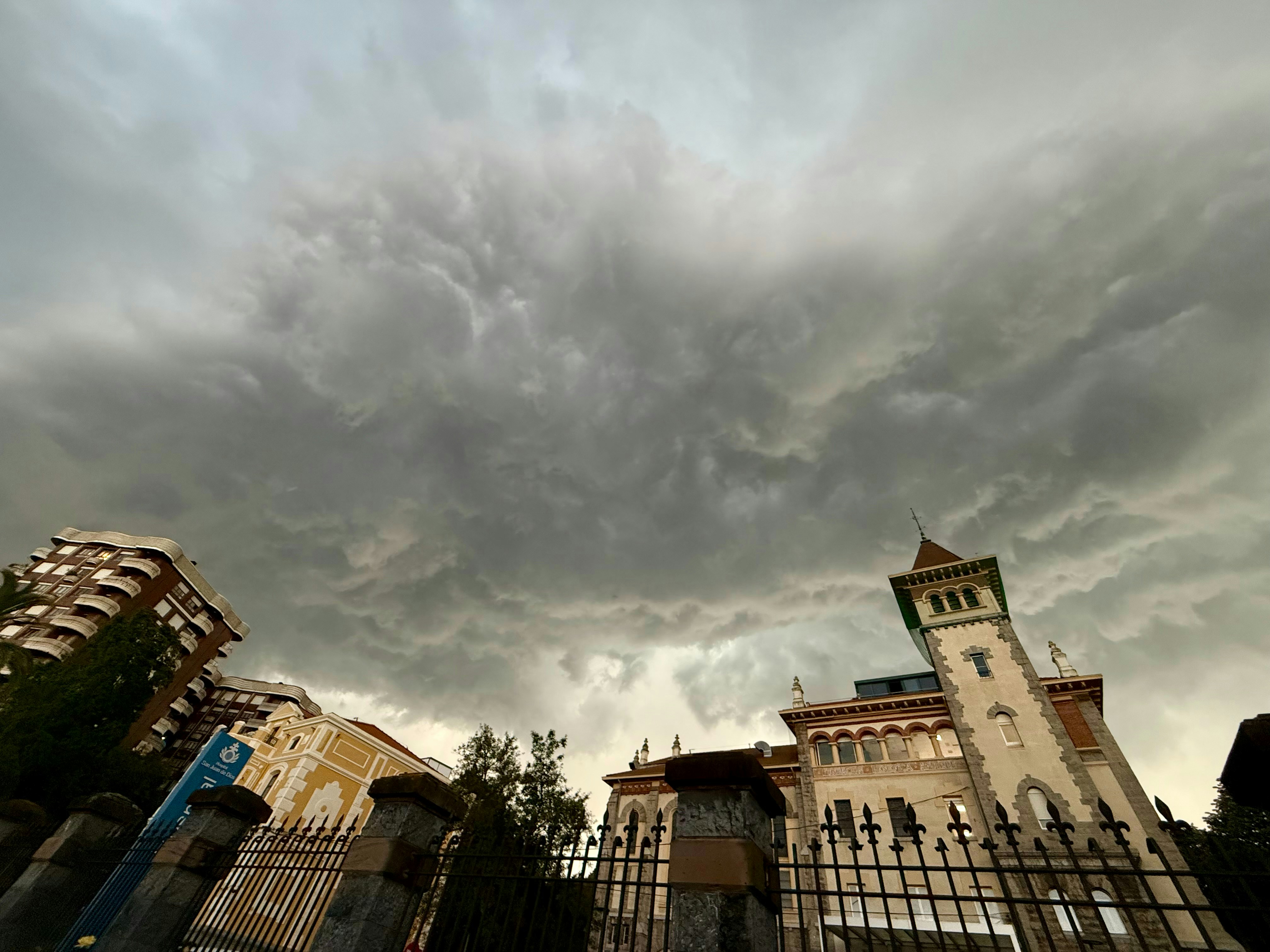 Dramatic storm clouds gather over ornate buildings.