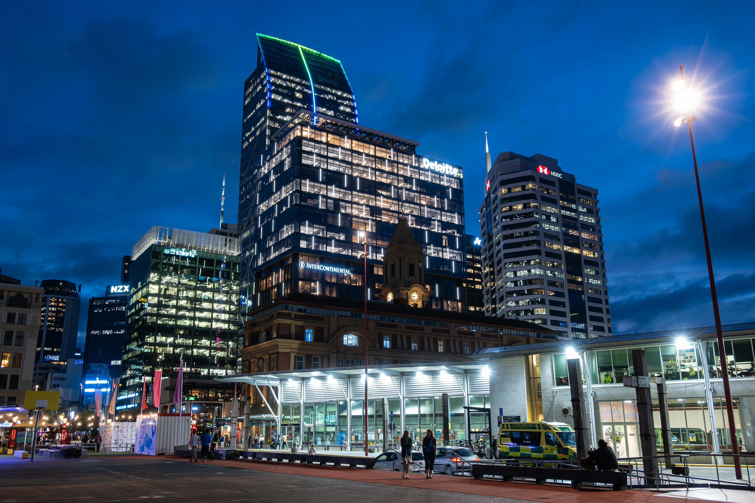 Modern cityscape with illuminated buildings at dusk.
