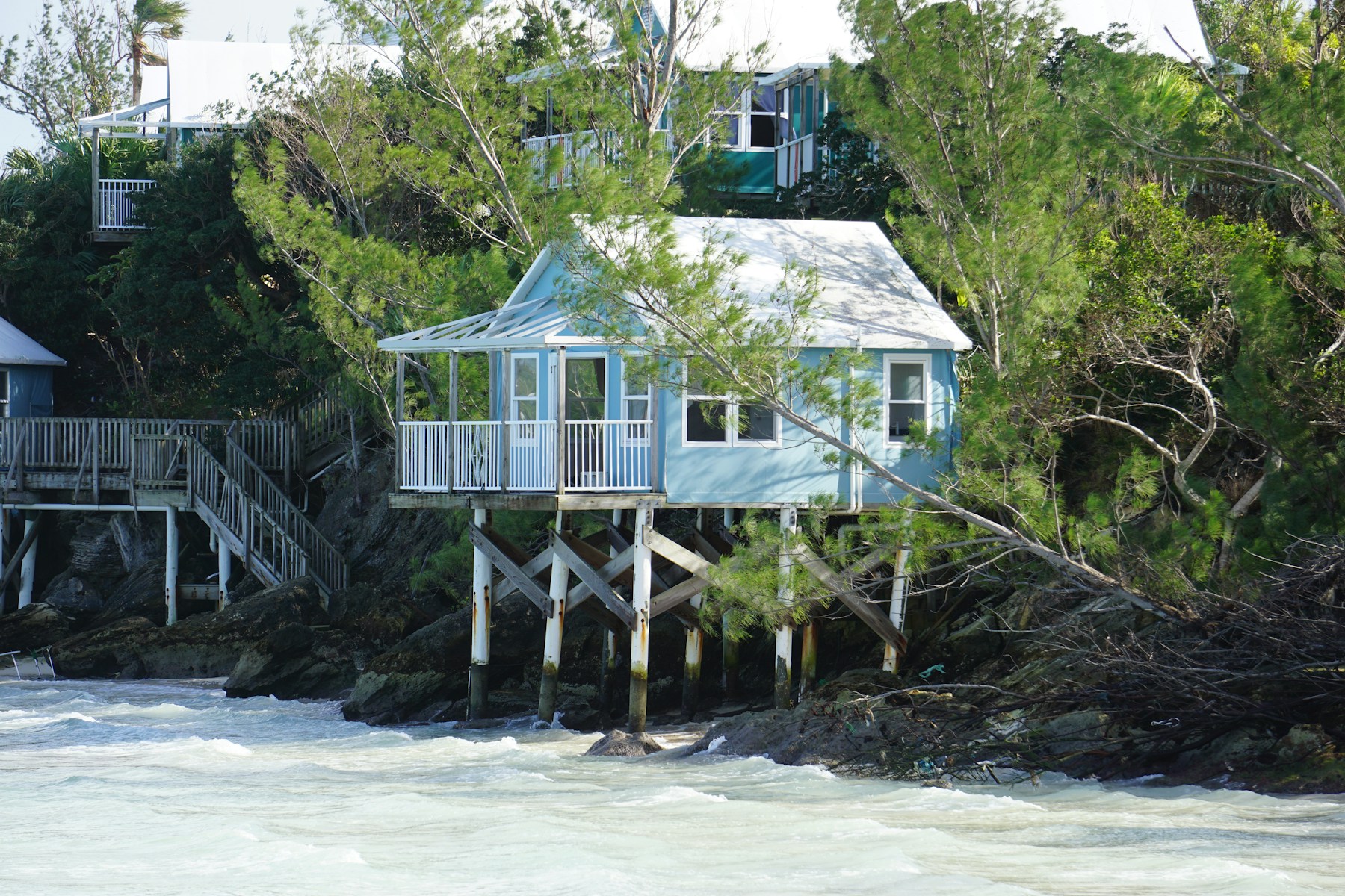 A light blue holiday house beside the water