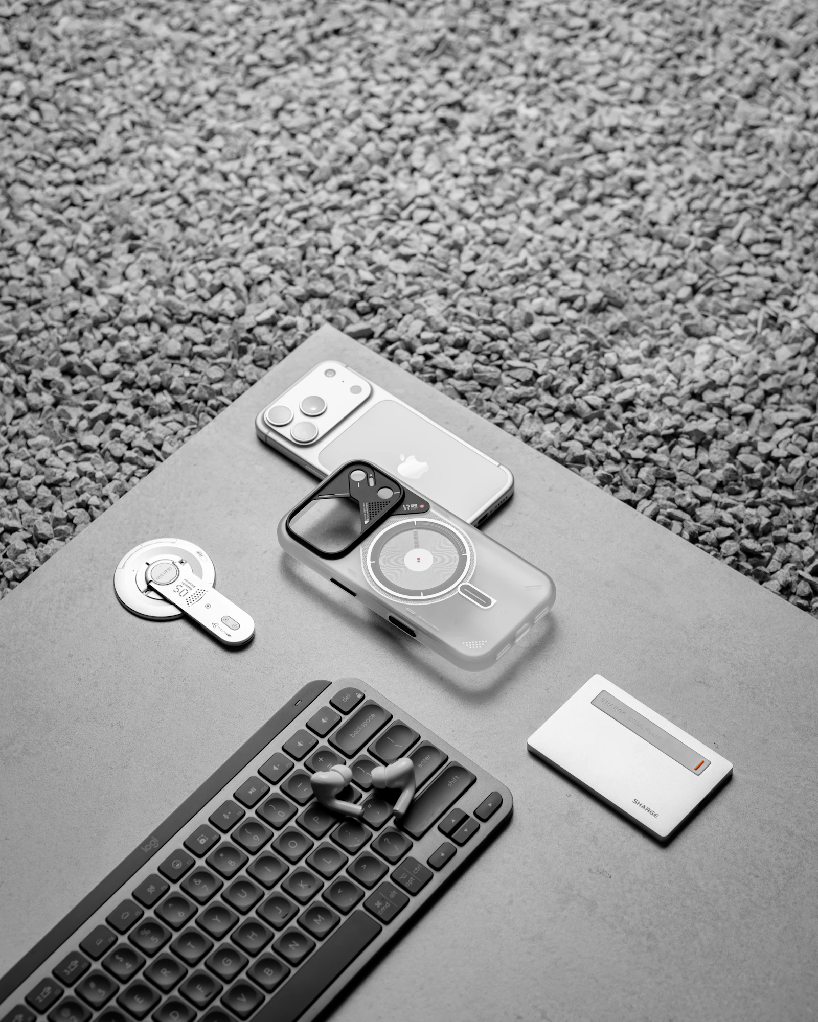 Smartphone, keyboard, earbuds, case and charging accessories arranged in a clean flat lay