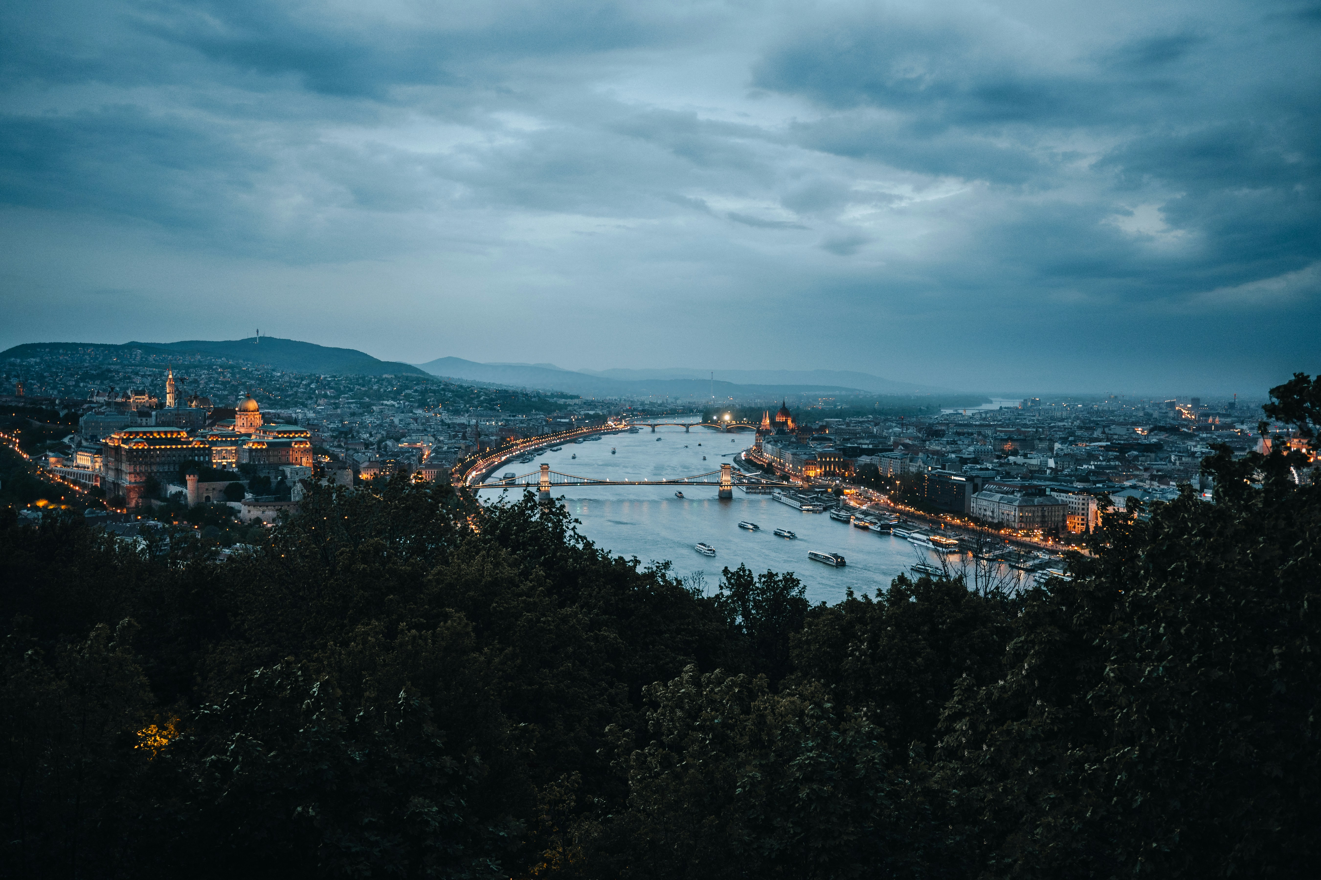 Cityscape with river and boats at dusk