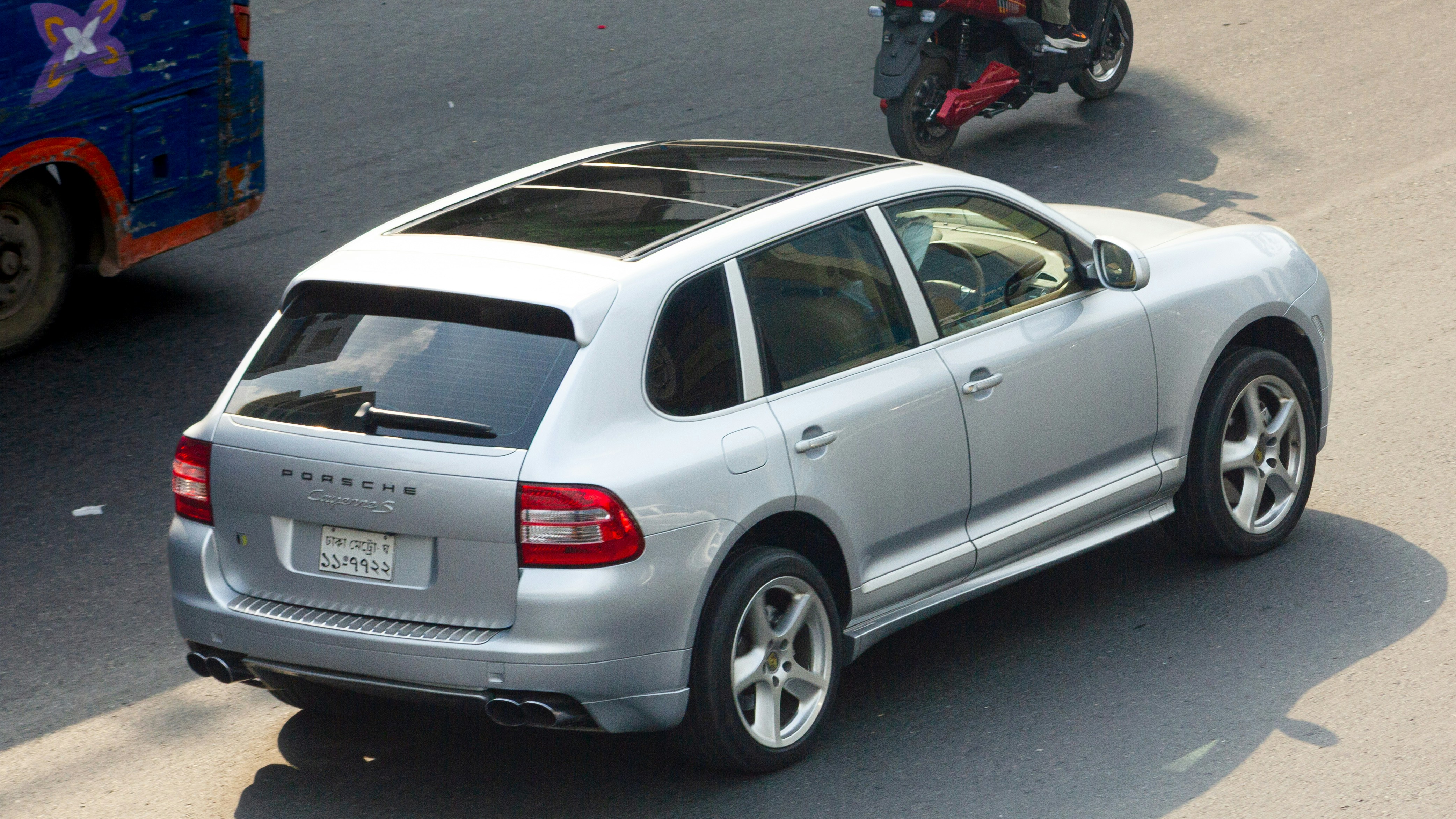 Silver porsche cayenne driving on a city street