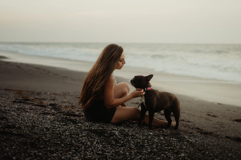 femme senior sur la plage avec son bouledogue français