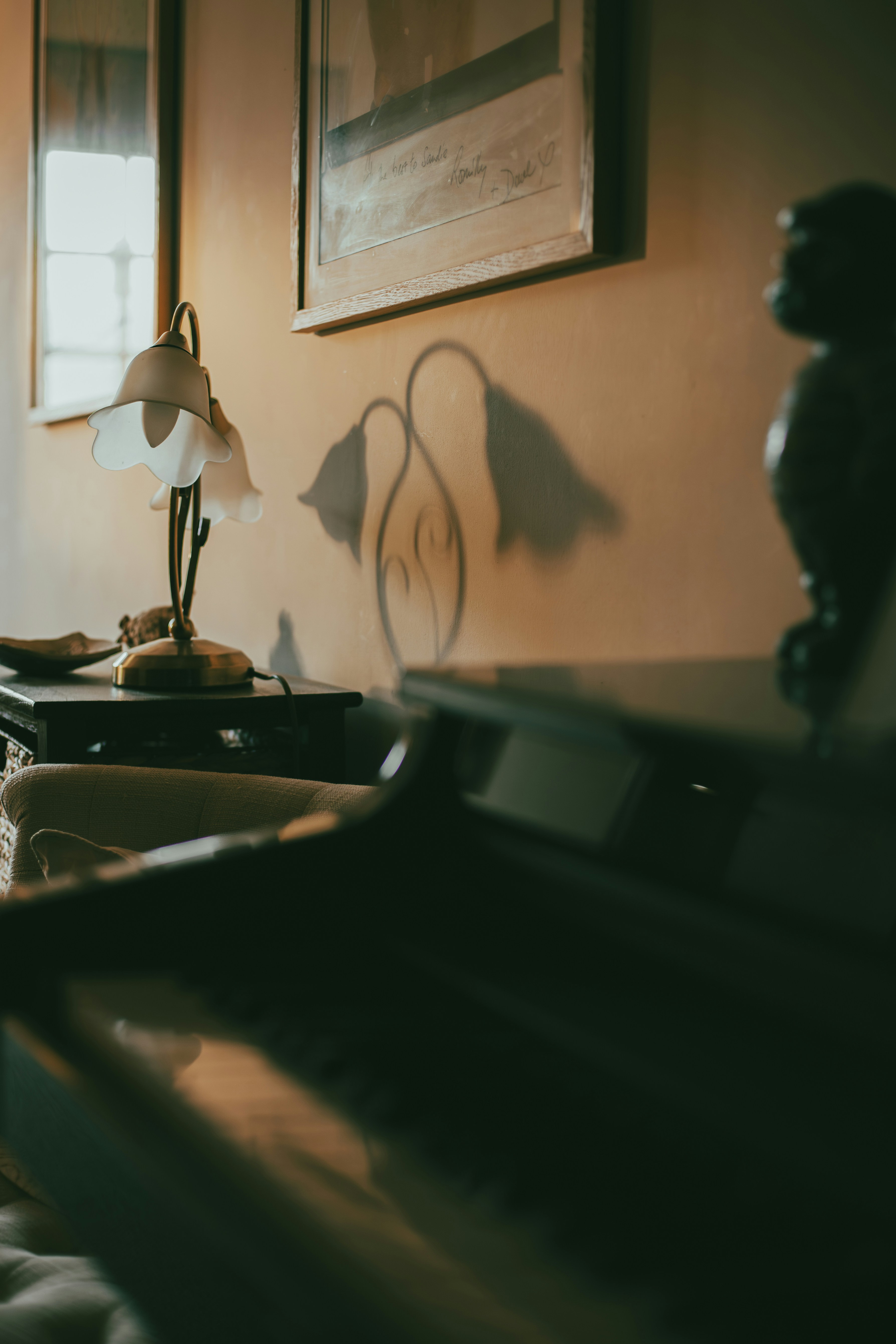 Une pièce faiblement éclairée avec un piano et une lampe.