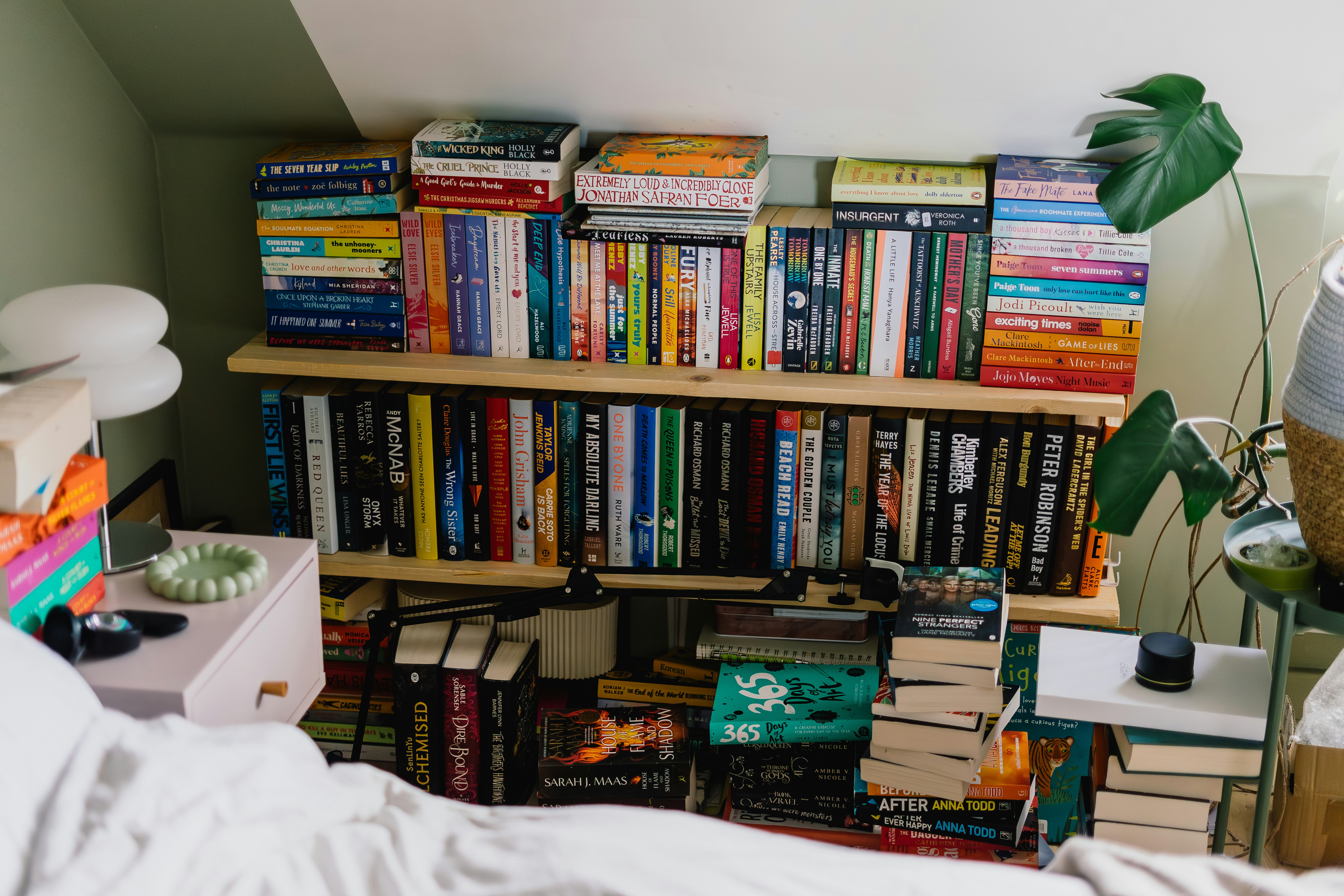 Bookshelves filled with books and stacked on the floor.